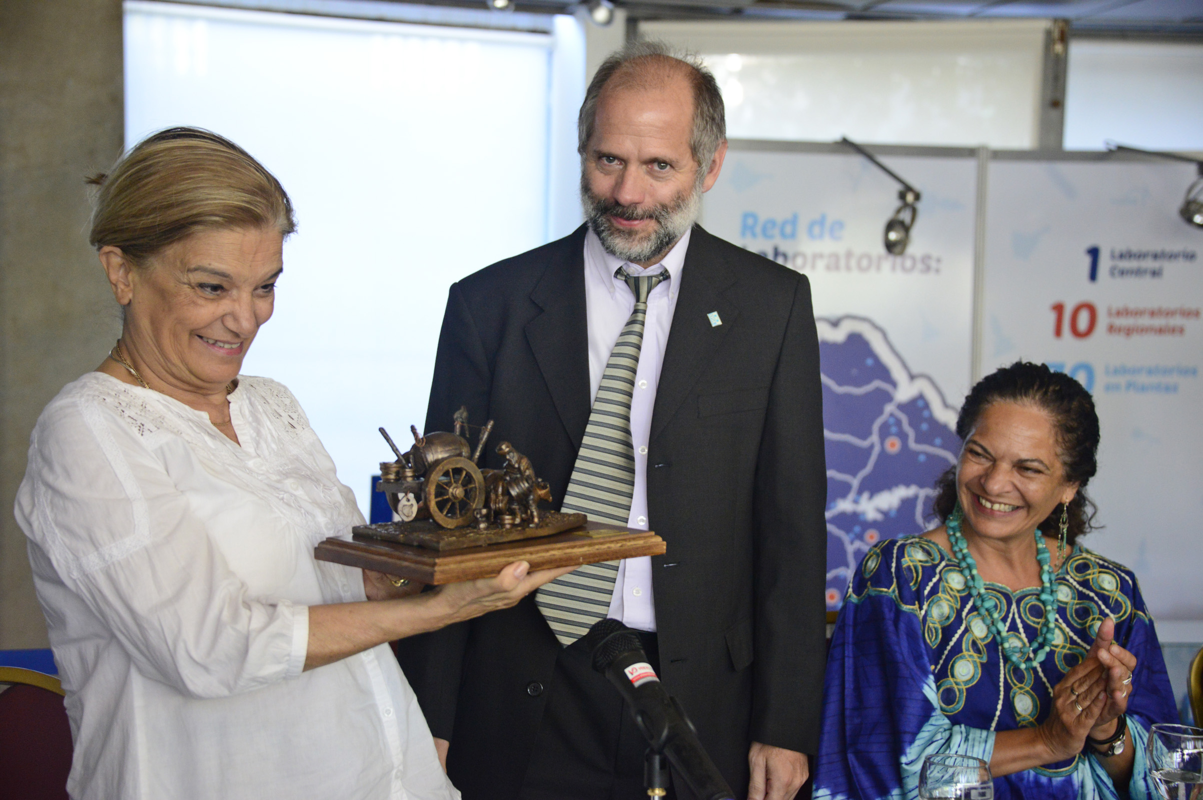 Eneida De León recibiendo un presente por parte del presidente de OSE, Milton Machado