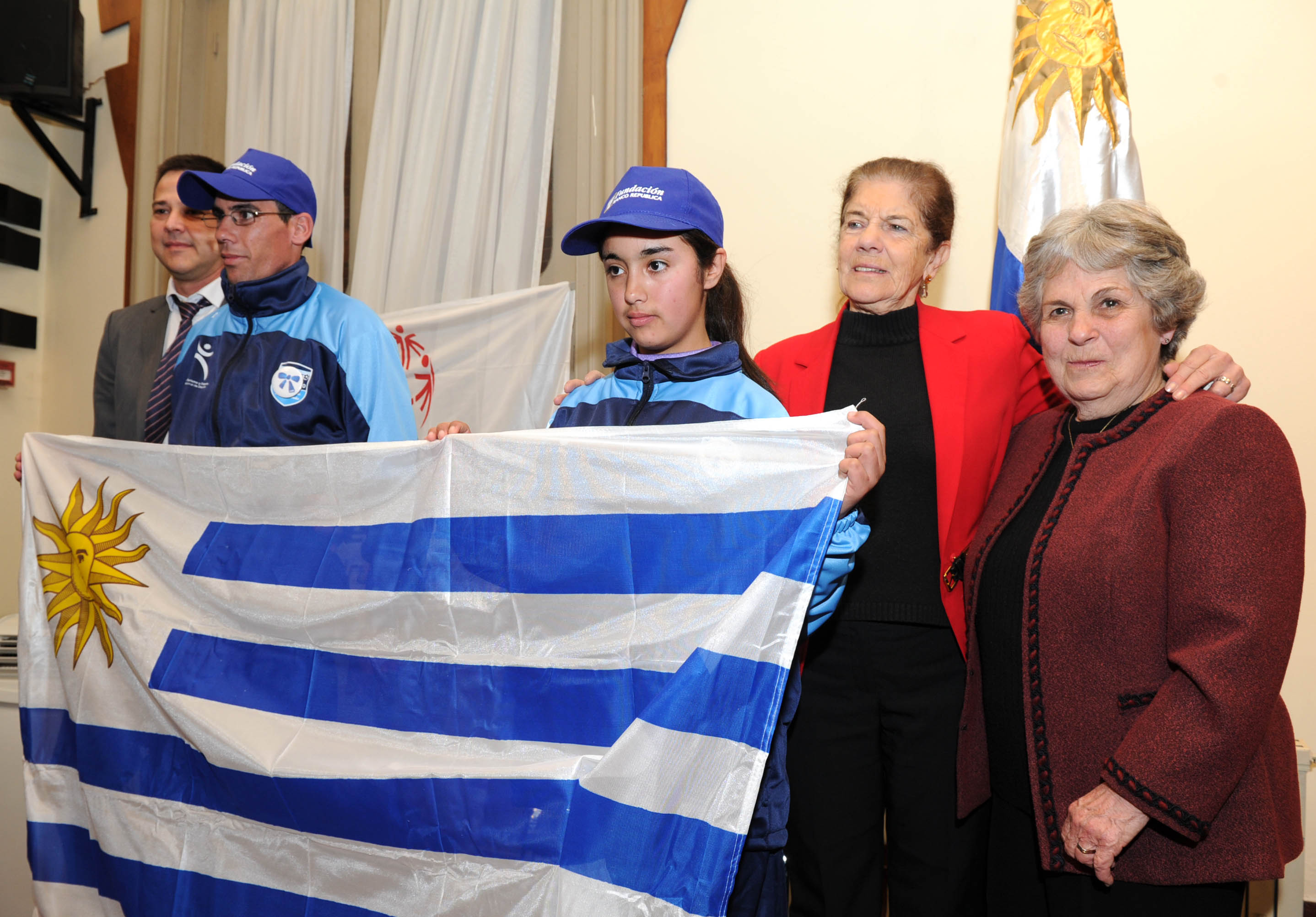 María Auxiliadora Delgado y Aurora Saroba haciendo entrega del Pabellón Nacional