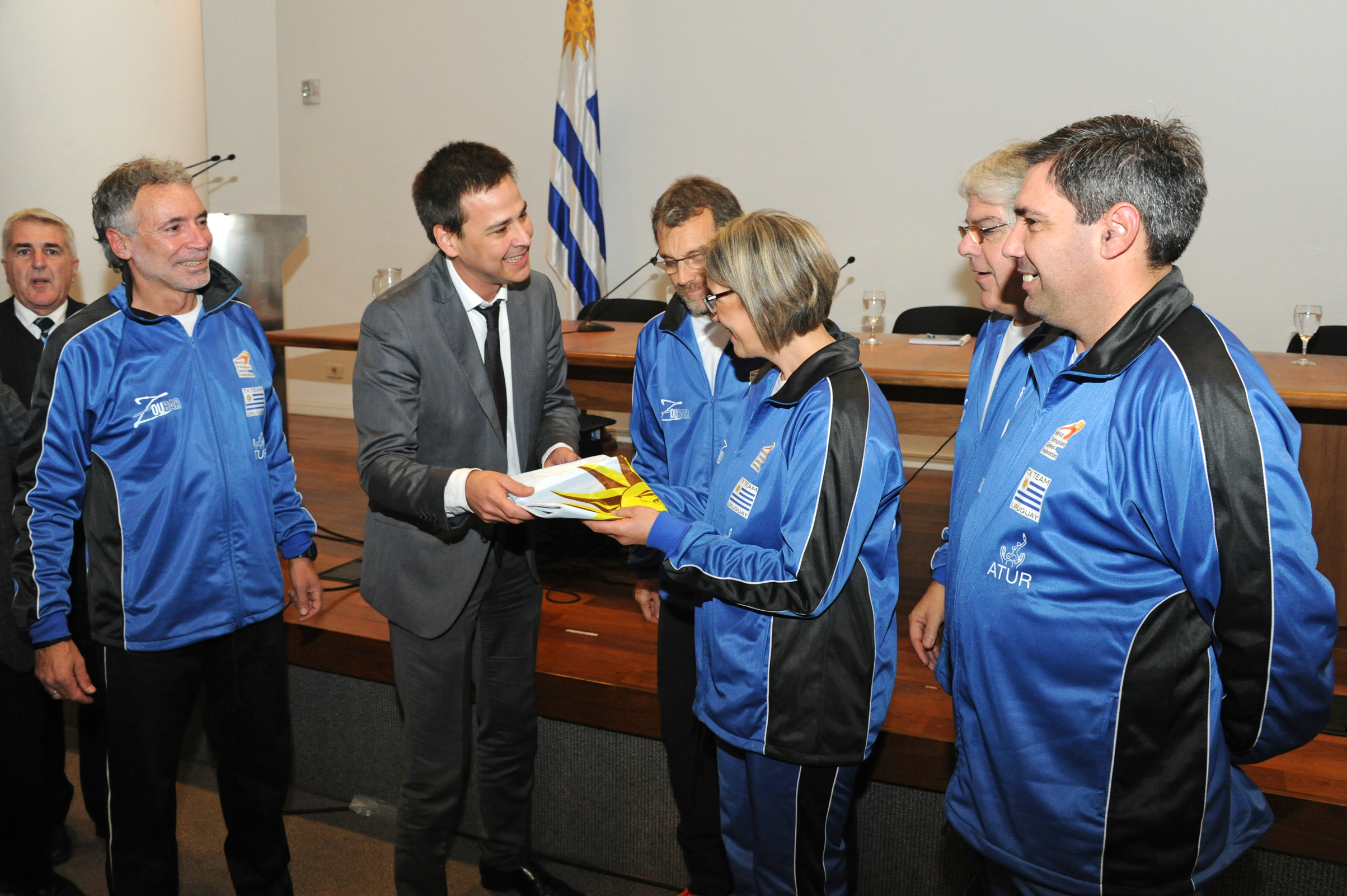 Representantes de la Secretaría Nacional del Deporte entregando el Pabellón Nacional