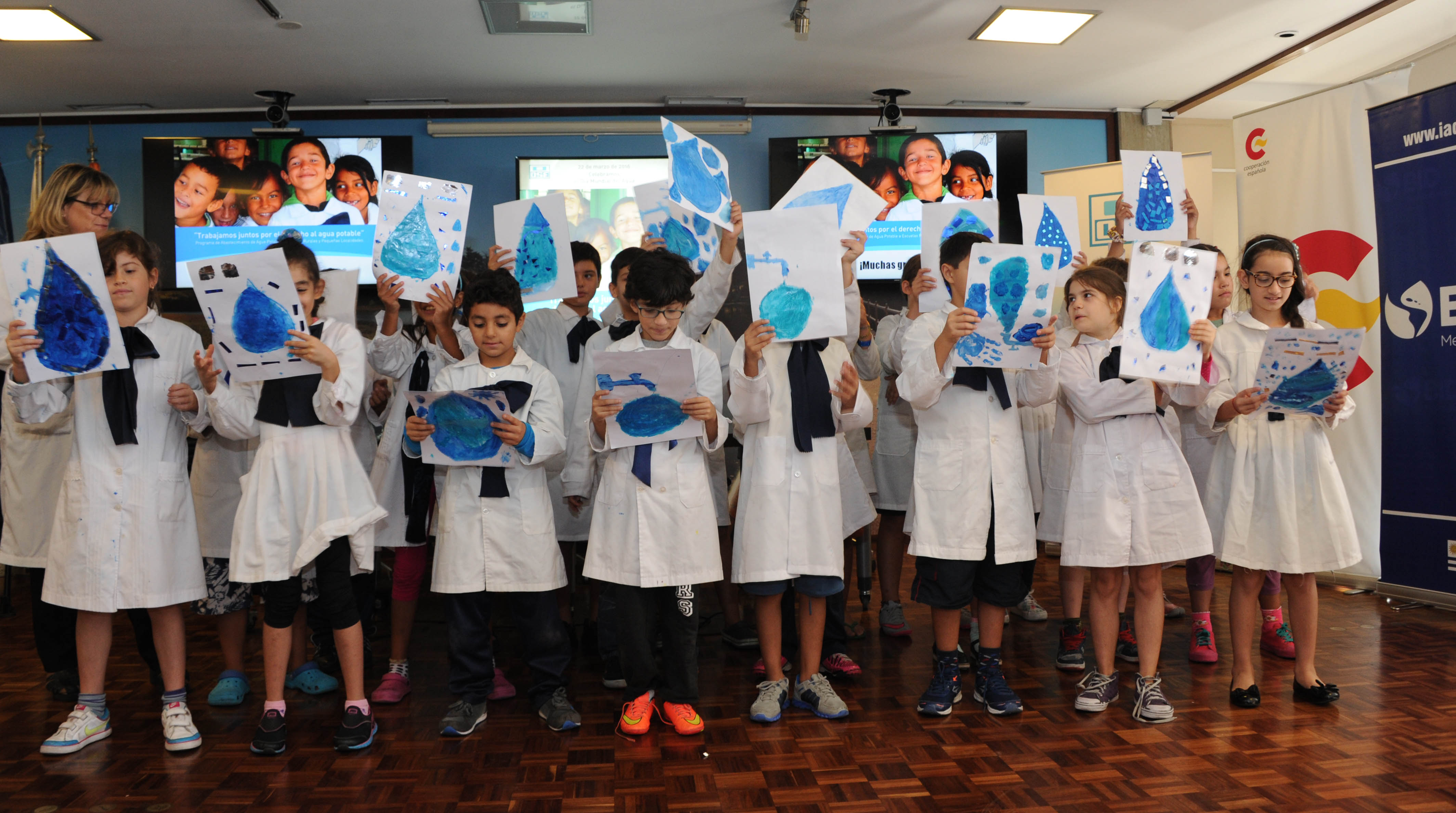 Escolares exhibiendo sus dibujos sobre el agua potable