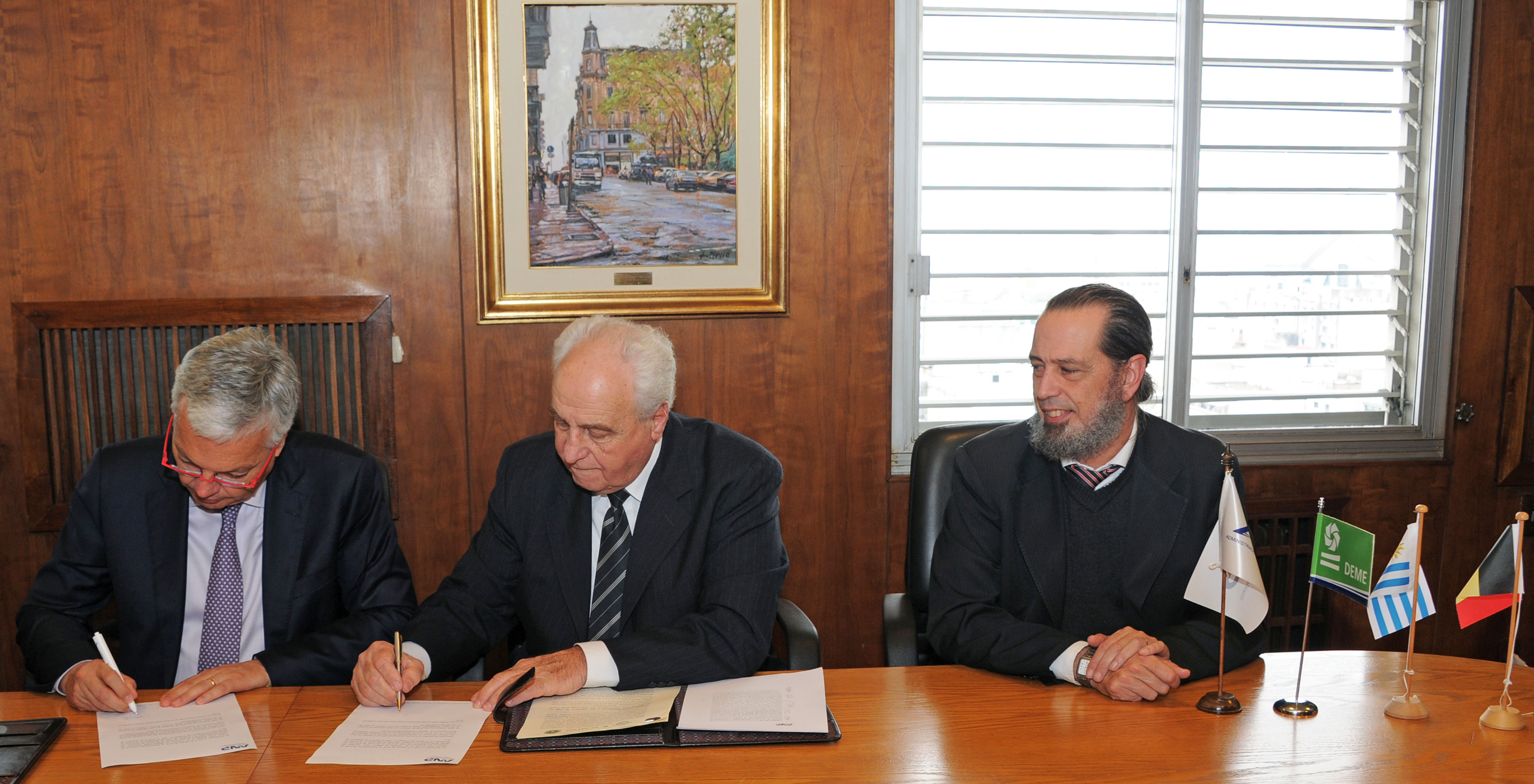 Firma de contrato entre Víctor Rossi y Didier Reynders