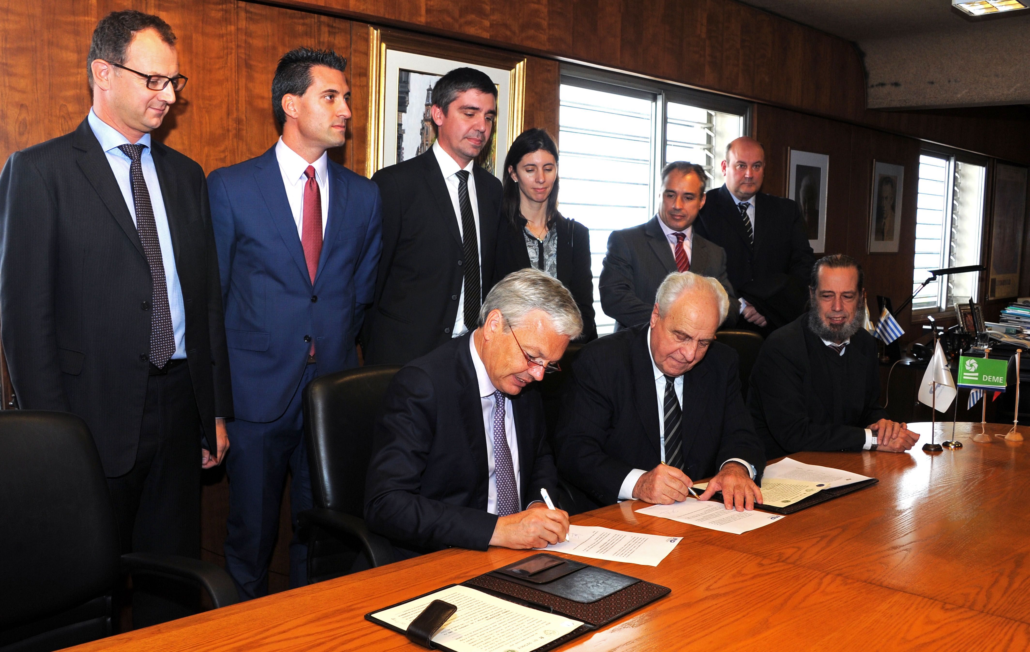 Firma de contrato entre Víctor Rossi y Didier Reynders