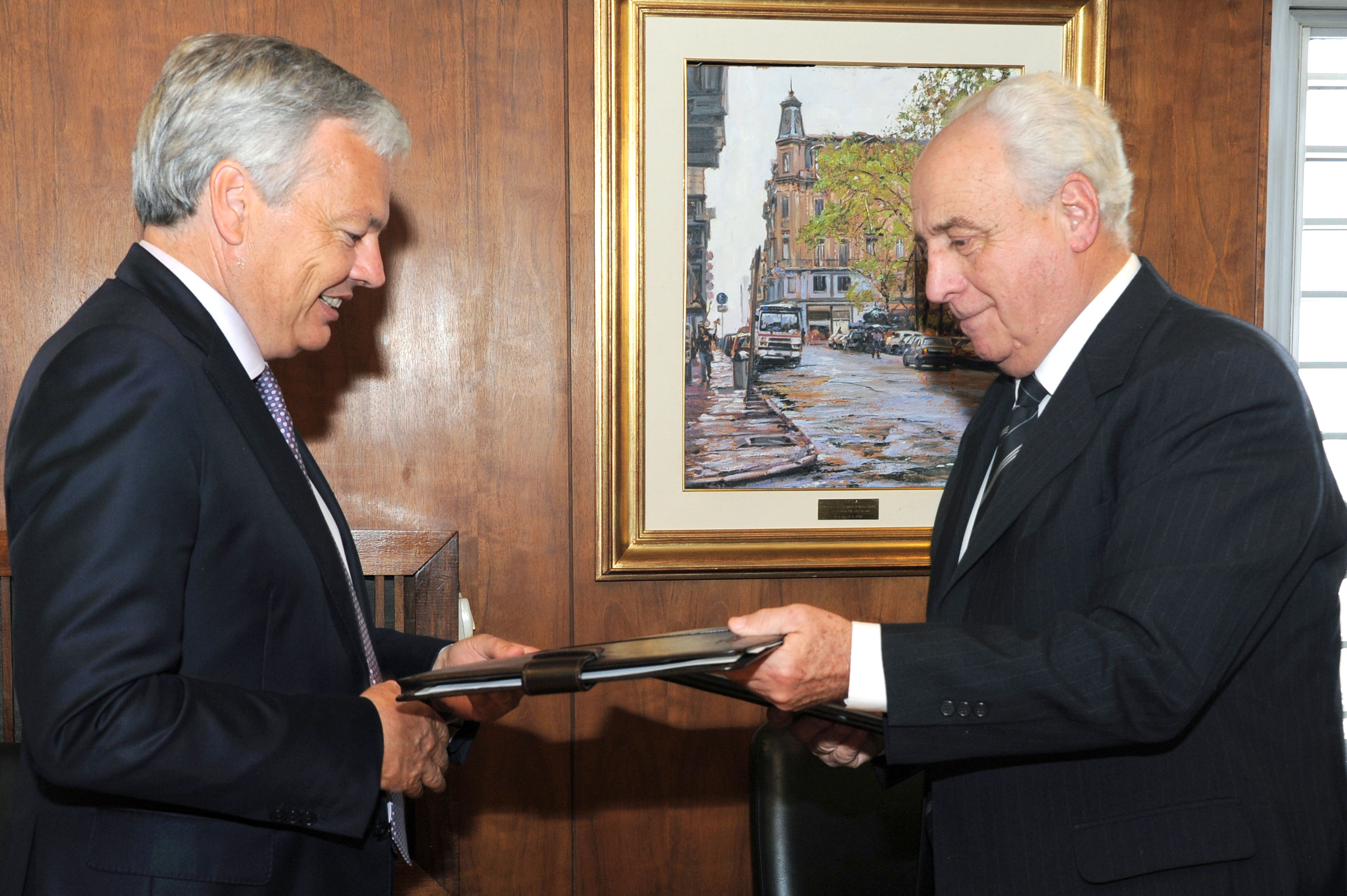 Firma de contrato entre Víctor Rossi y Didier Reynders