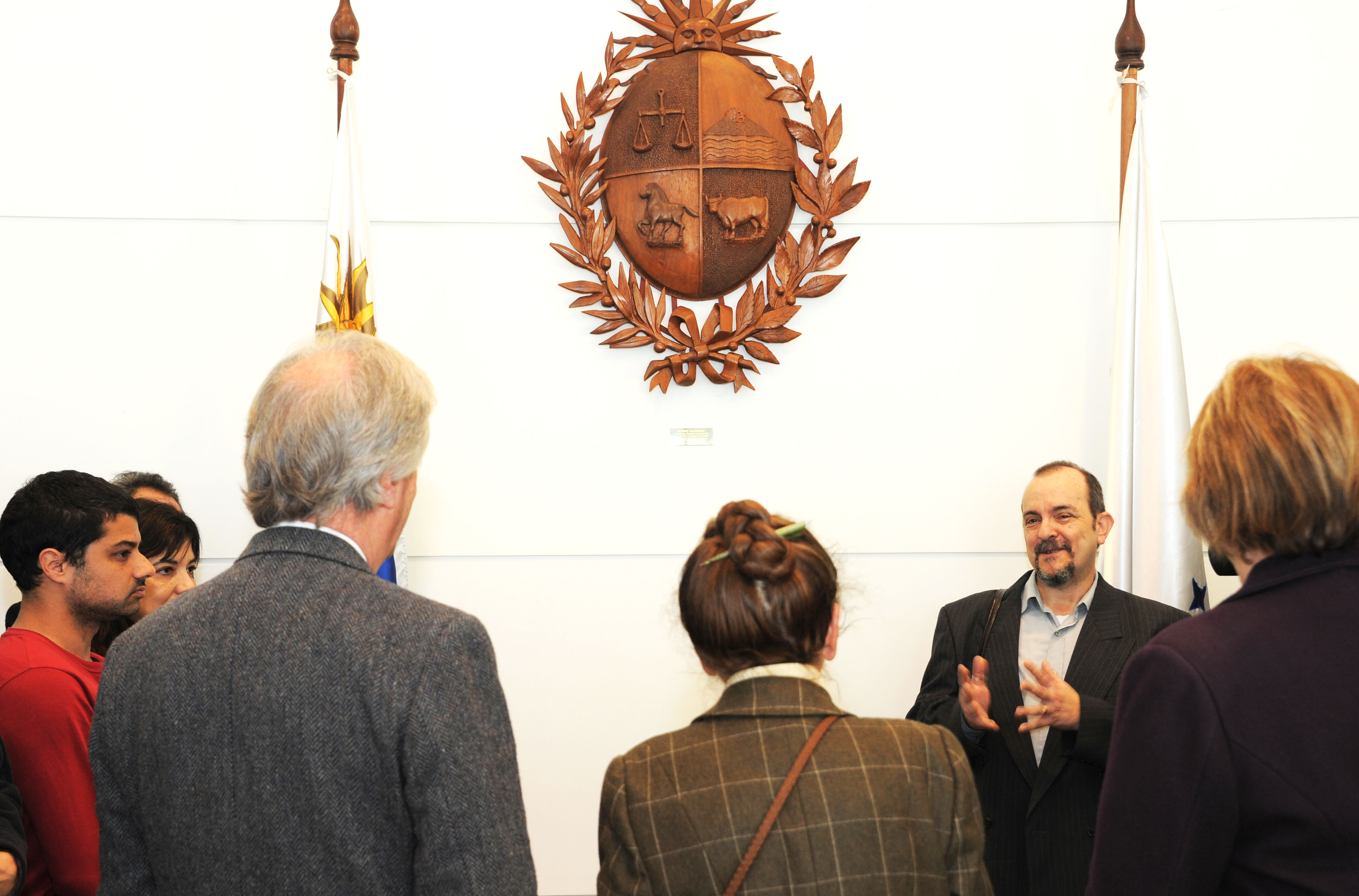 Vázquez, ministros y representantes de la UTU observan el Escudo Nacional en madera