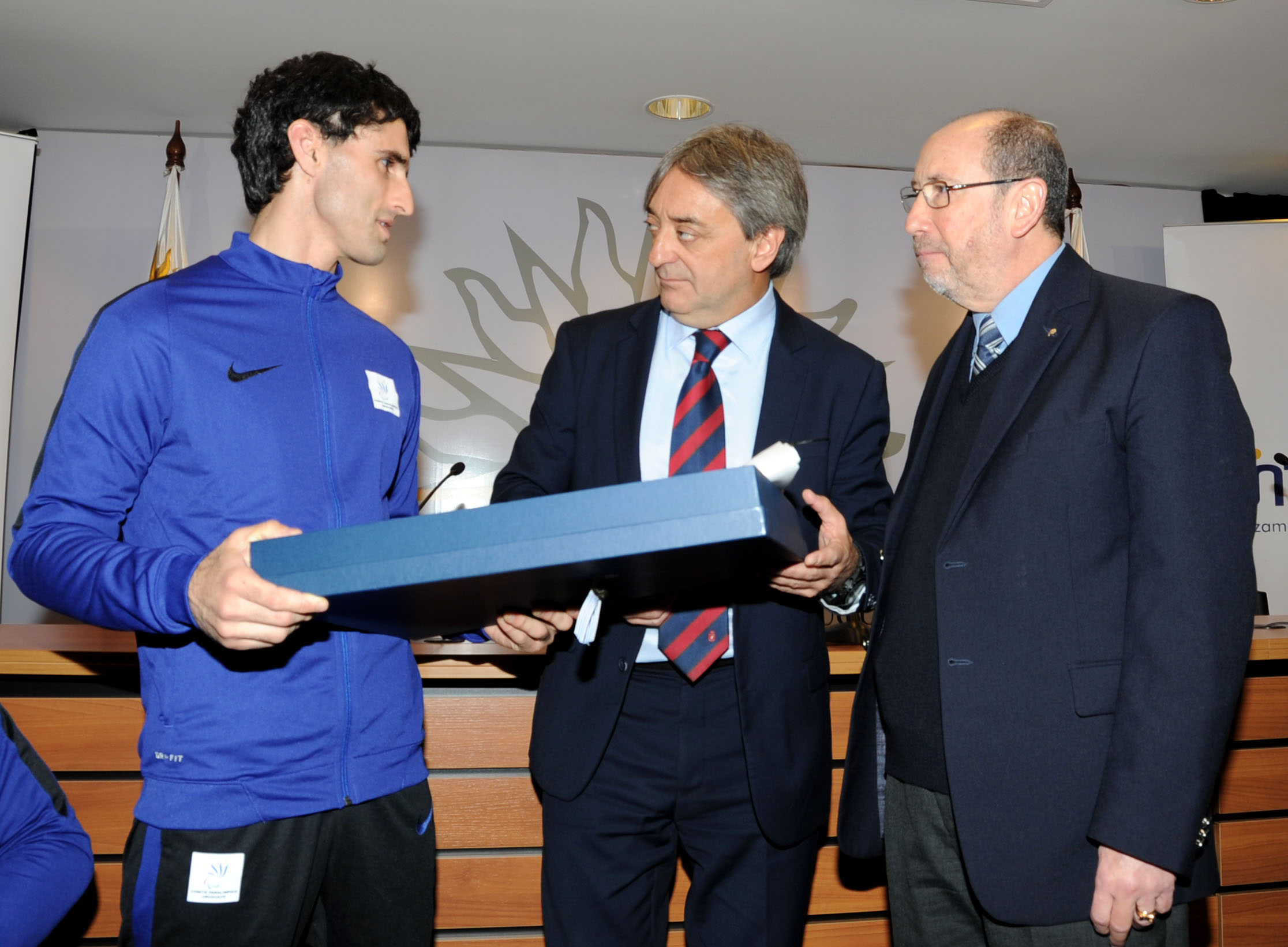 Fernando Cácers y Alfredo Etchandy hacen entrega del Pabellón Nacional a representante de la Delegación Uruguaya