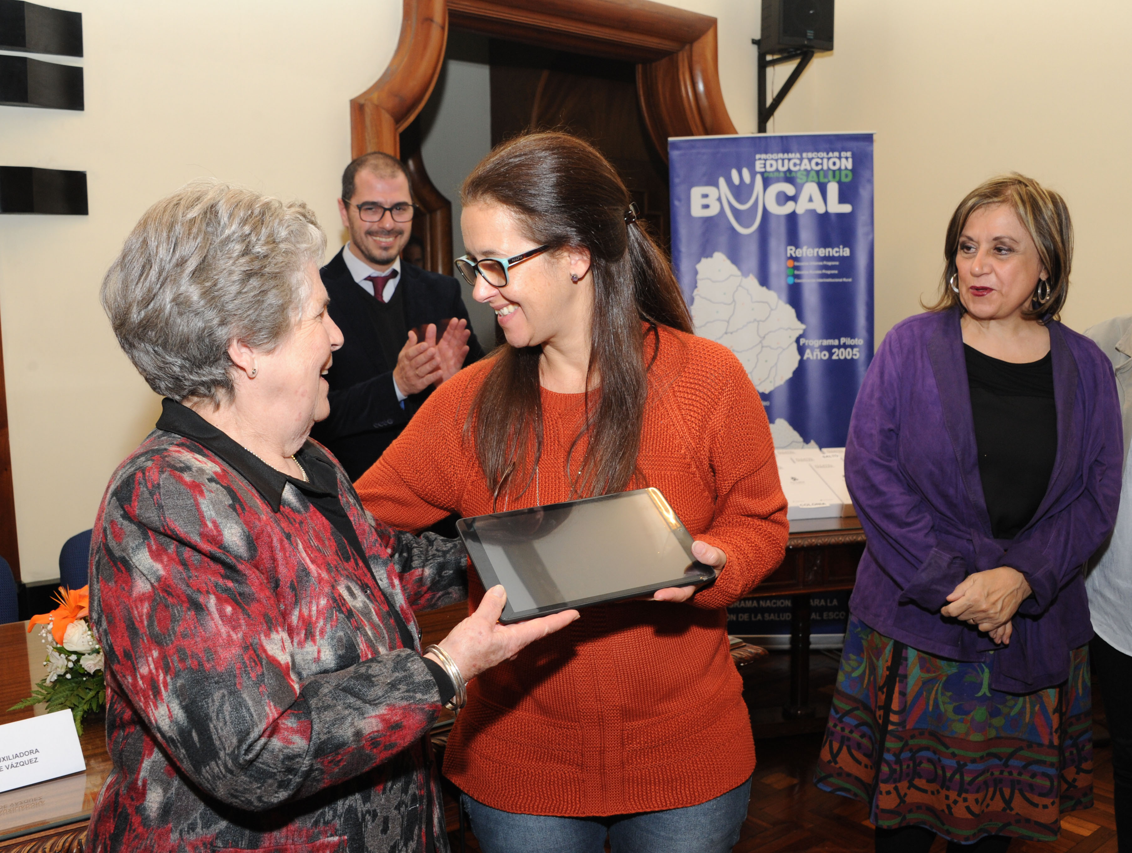 María Auxiliadora de Vázquez hace entrega de una tableta a odontólogo