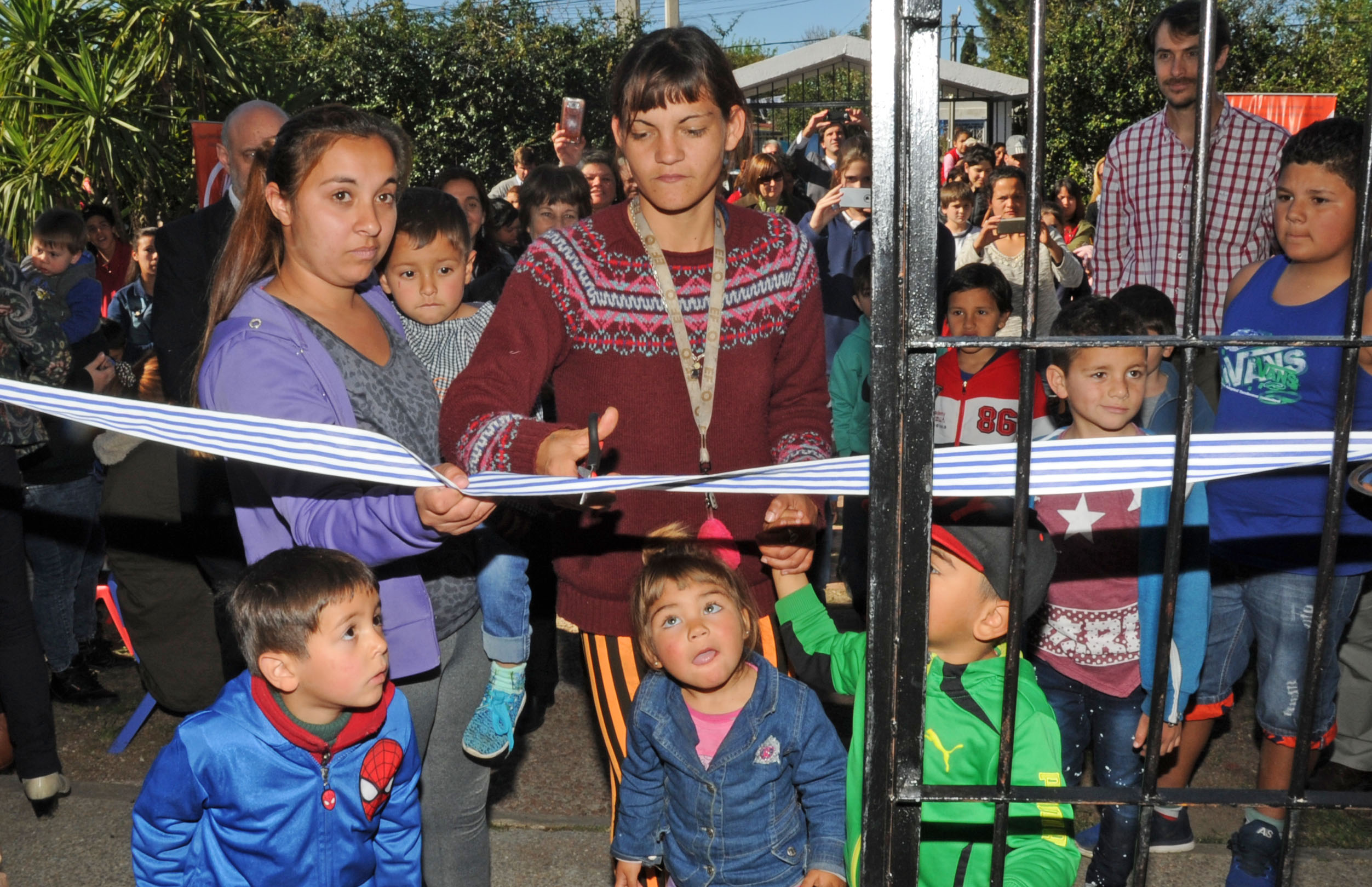 Corte de cinta por parte de padres y niños del CAIF