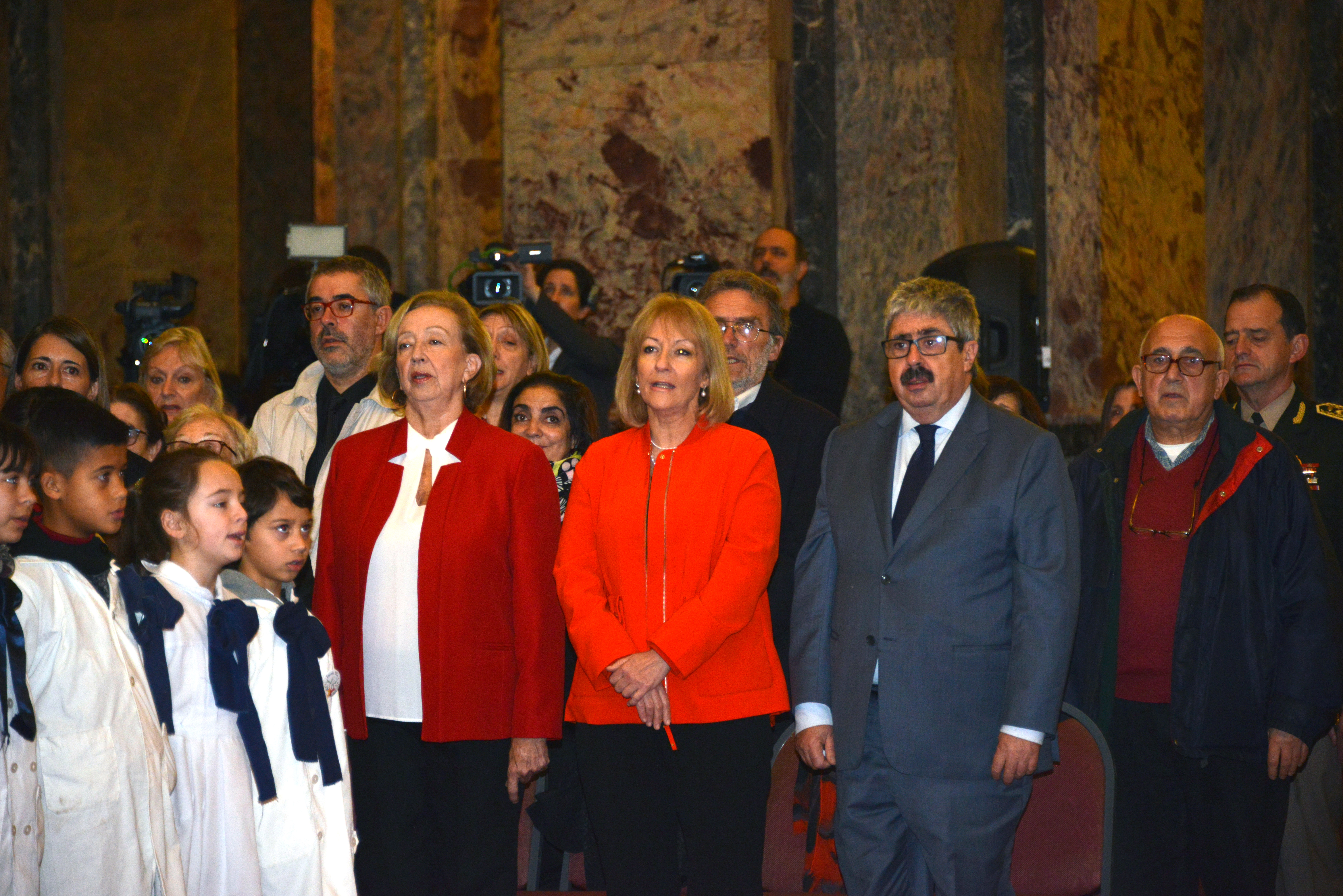 Autoridades y escolares entonando el Himno Nacional