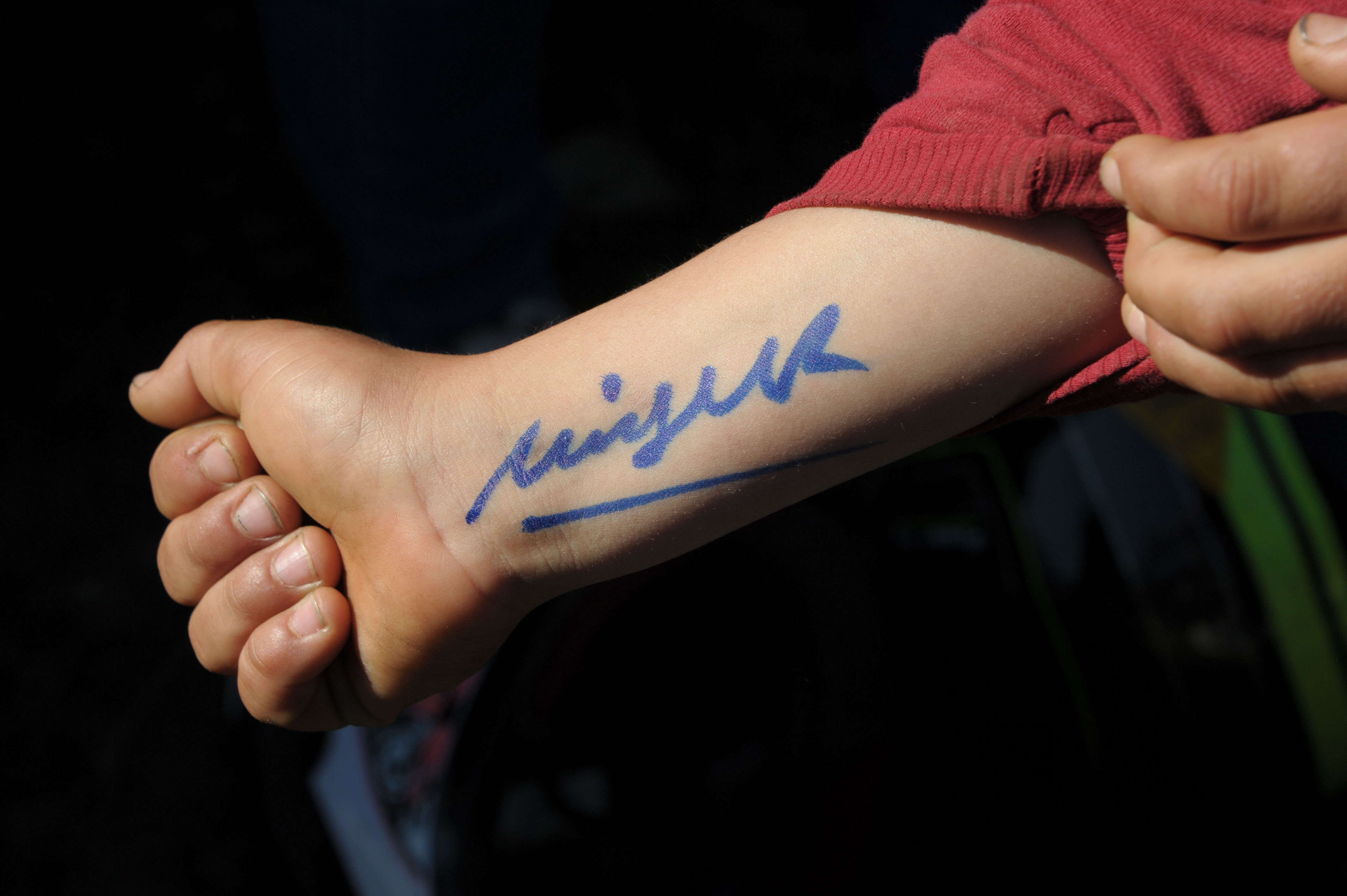 Firma del presidente estampada en el brazo de un niño