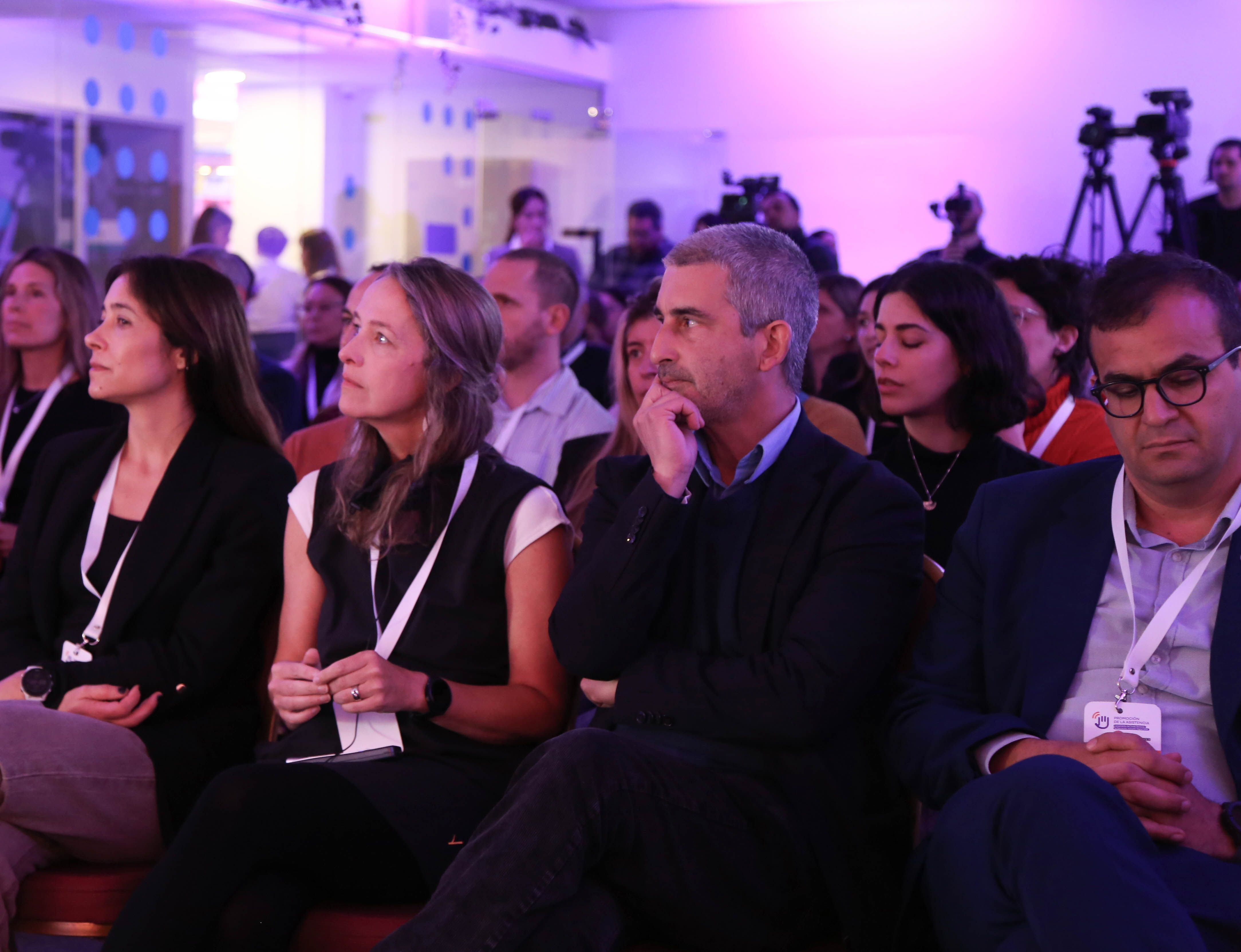 Presidente de la ANEP junto a otros participantes sentados en primera fila miran hacia el escenario y escuchan una disertación.
