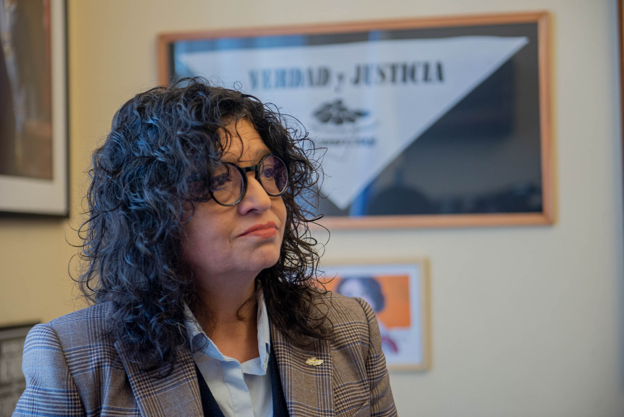 Primer plano de la directora de Derechos Humanos para el Pasado Reciente mirando hacia un costado. Atrás cartel con las palabras: verdad y justicia.