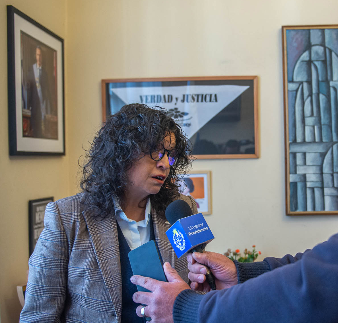 Directora de Derechos Humanos para el Pasado Reciente frente a un micrófono de Presidencia dialoga con un periodista.