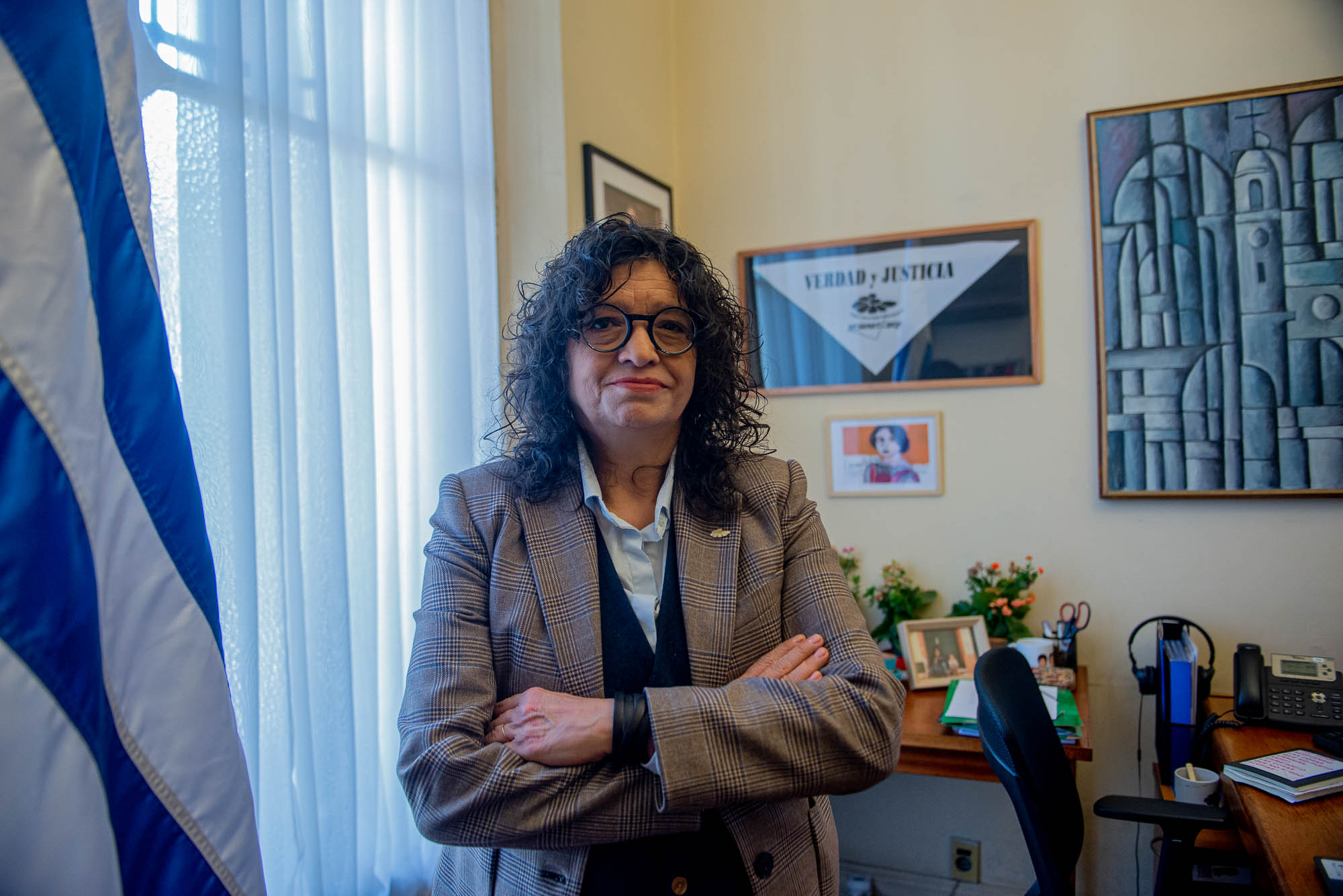Directora de Derechos Humanos para el Pasado Reciente posa sonriente frente a cámara en su despacho.