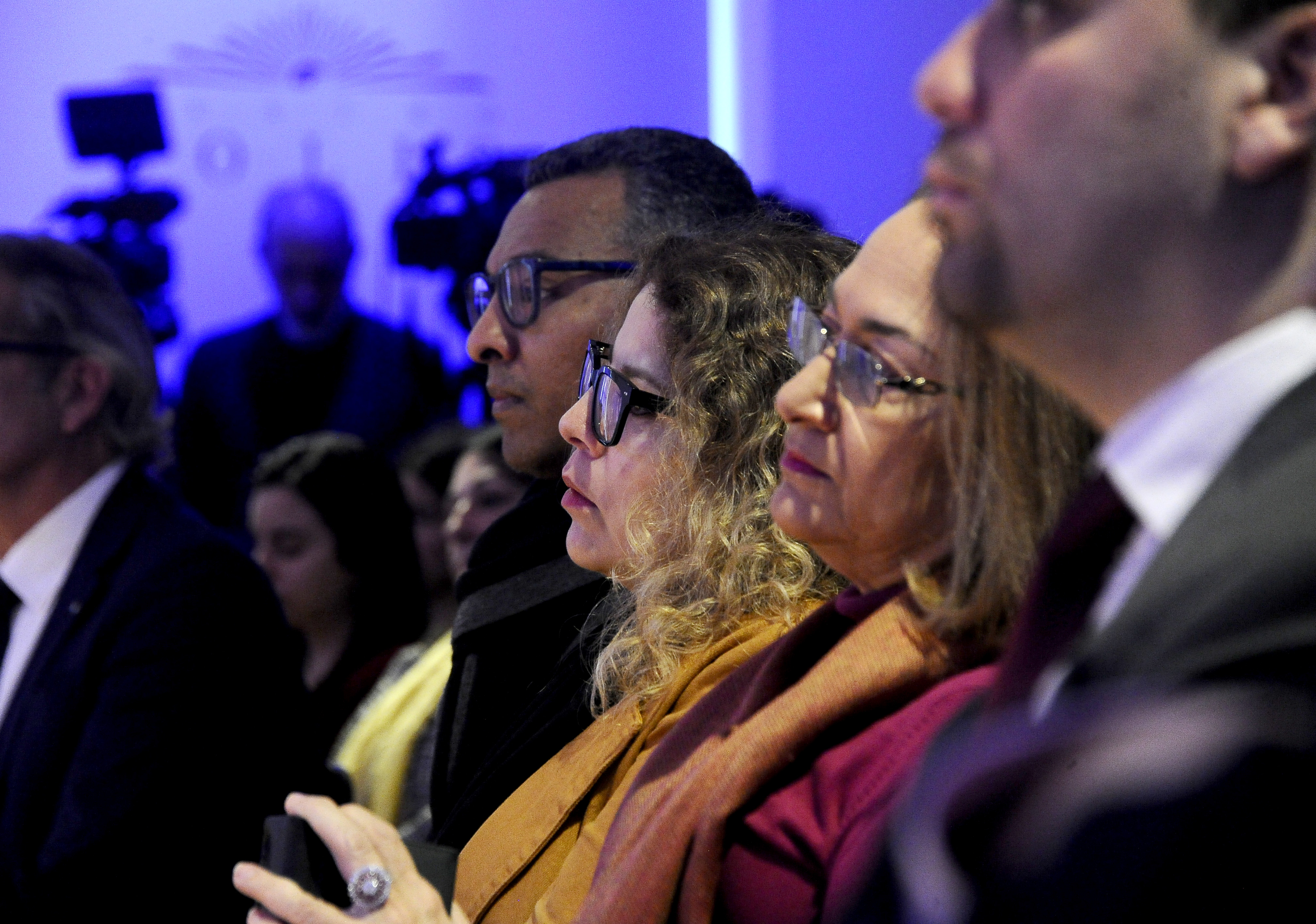Plano más cercano del público sentado en la platea del teatro Solís mira hacia el escenario y escuchan una disertación.