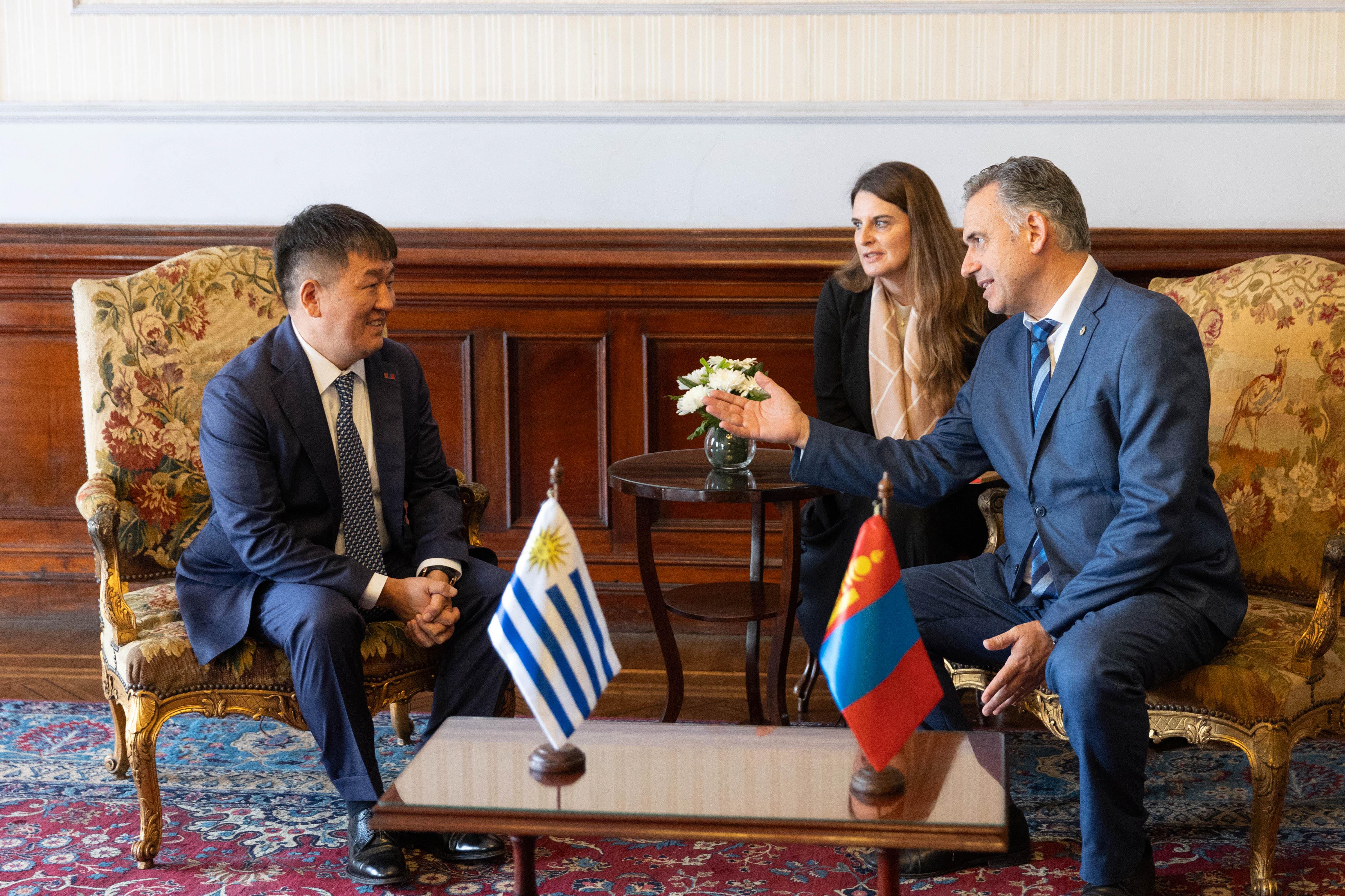 Orsi y embajador de Mongolia sentados en sillones dialogan entre sí. Atrás una traductora los observa.