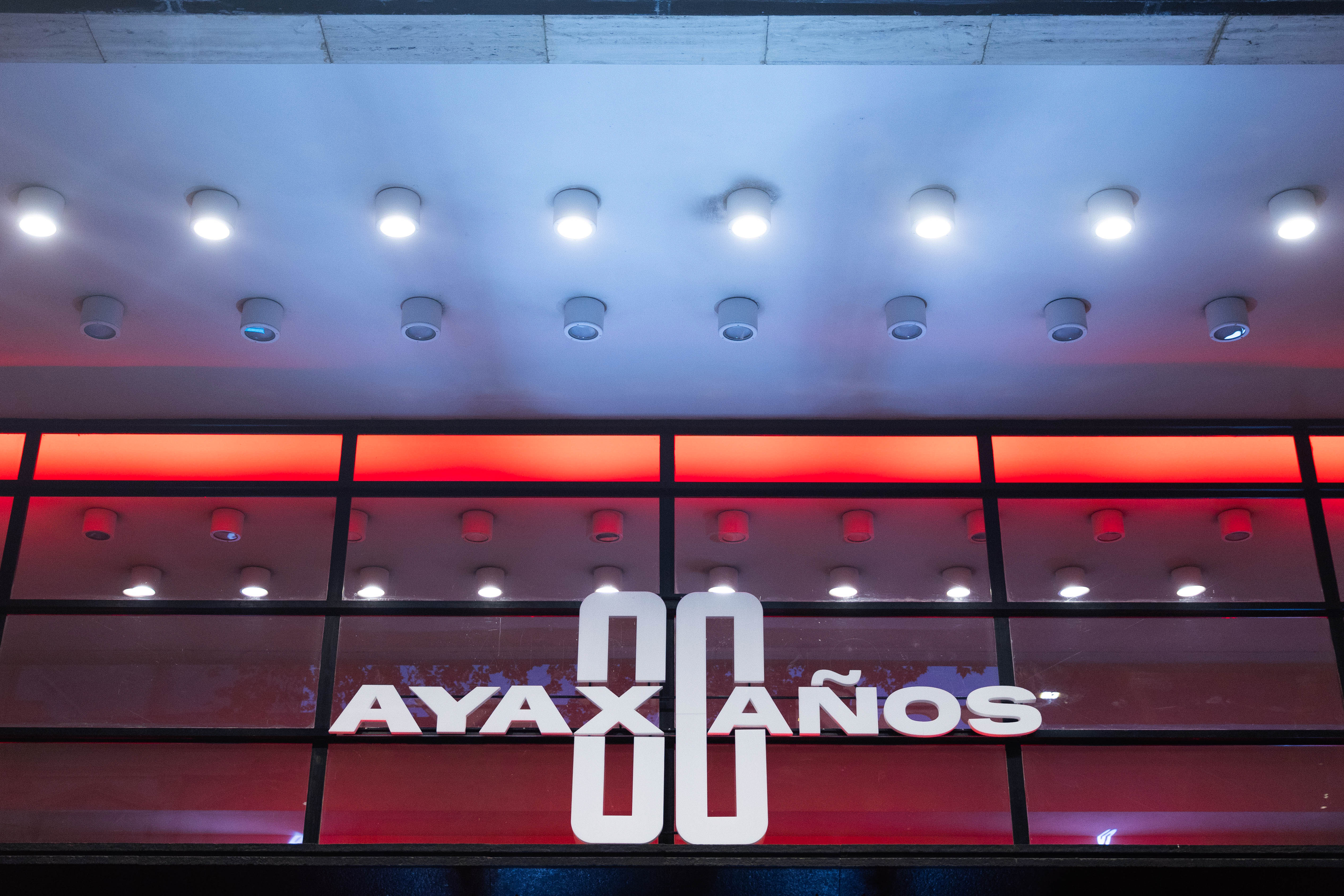 Fachada del Auditorio Nacional del Sodre con varias luces y un cartel que dice: Ayax 80 años en letras grandes y blancas. 