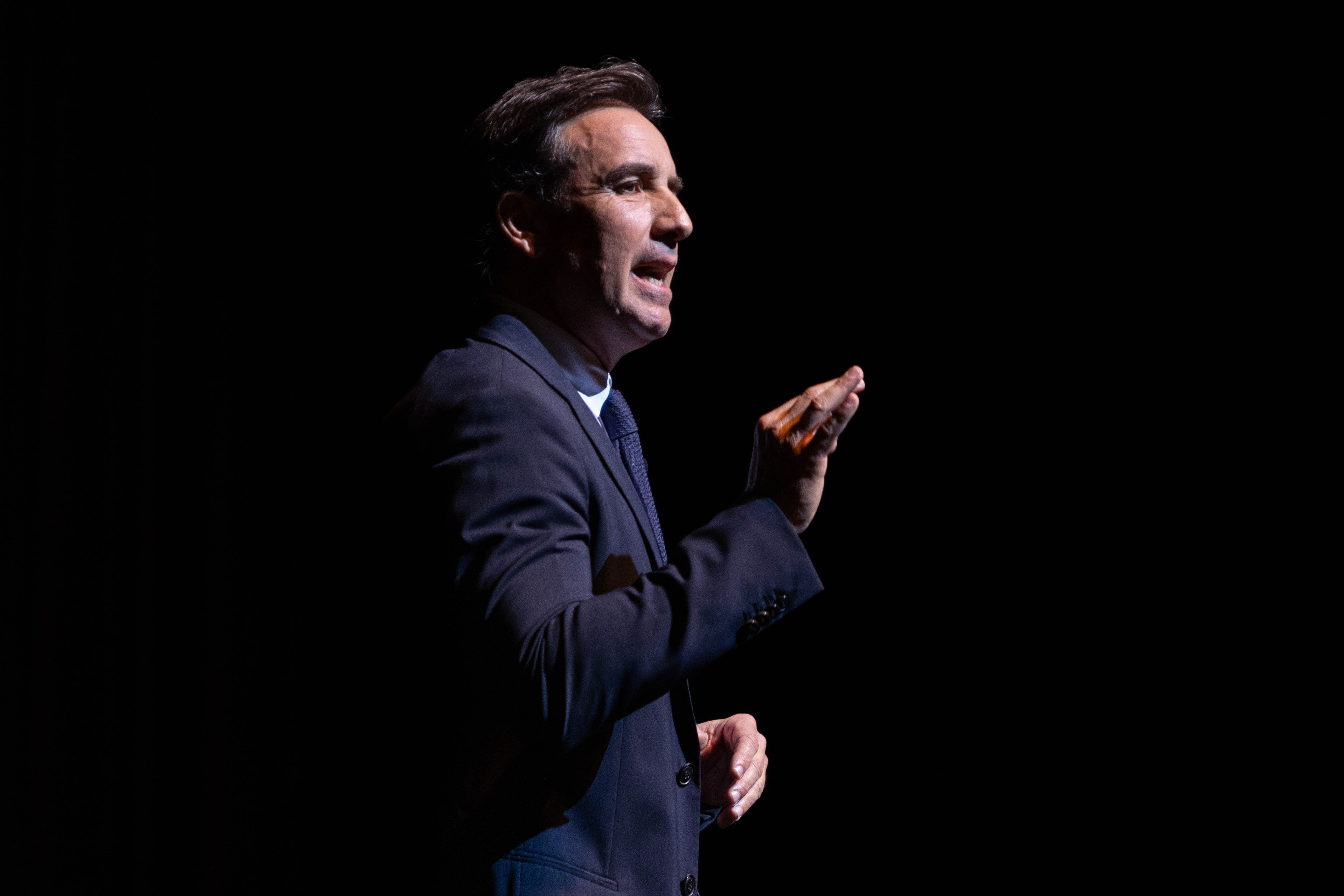 Directivo de Ayax diserta parado en el escenario.