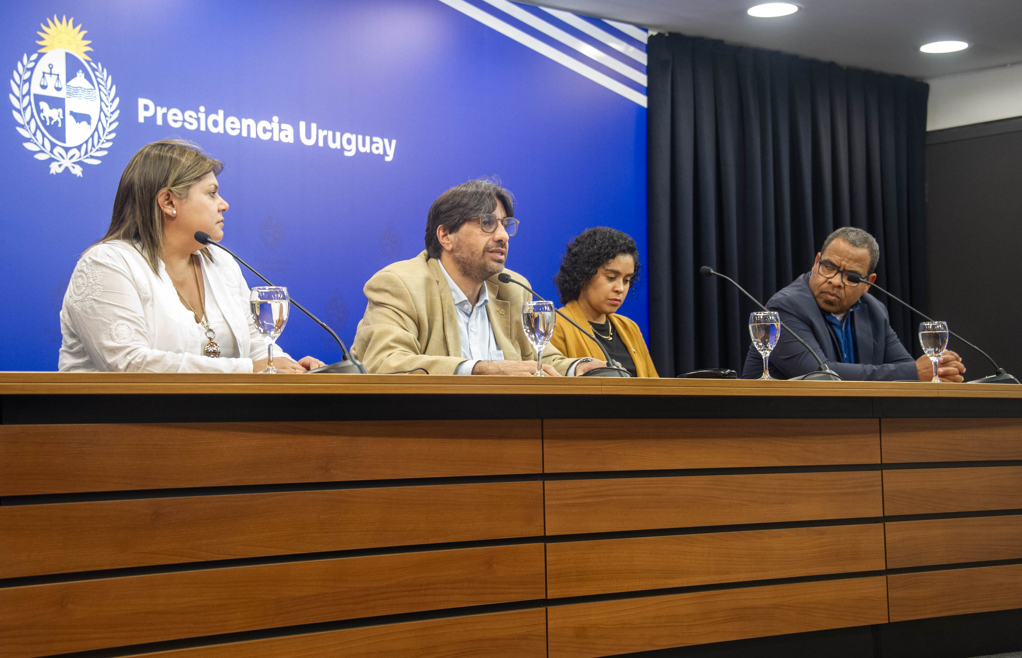 Presidente de la Unasev diserta sentado en mesa con micrófono junto a los directores y secretaria general del organismo.
