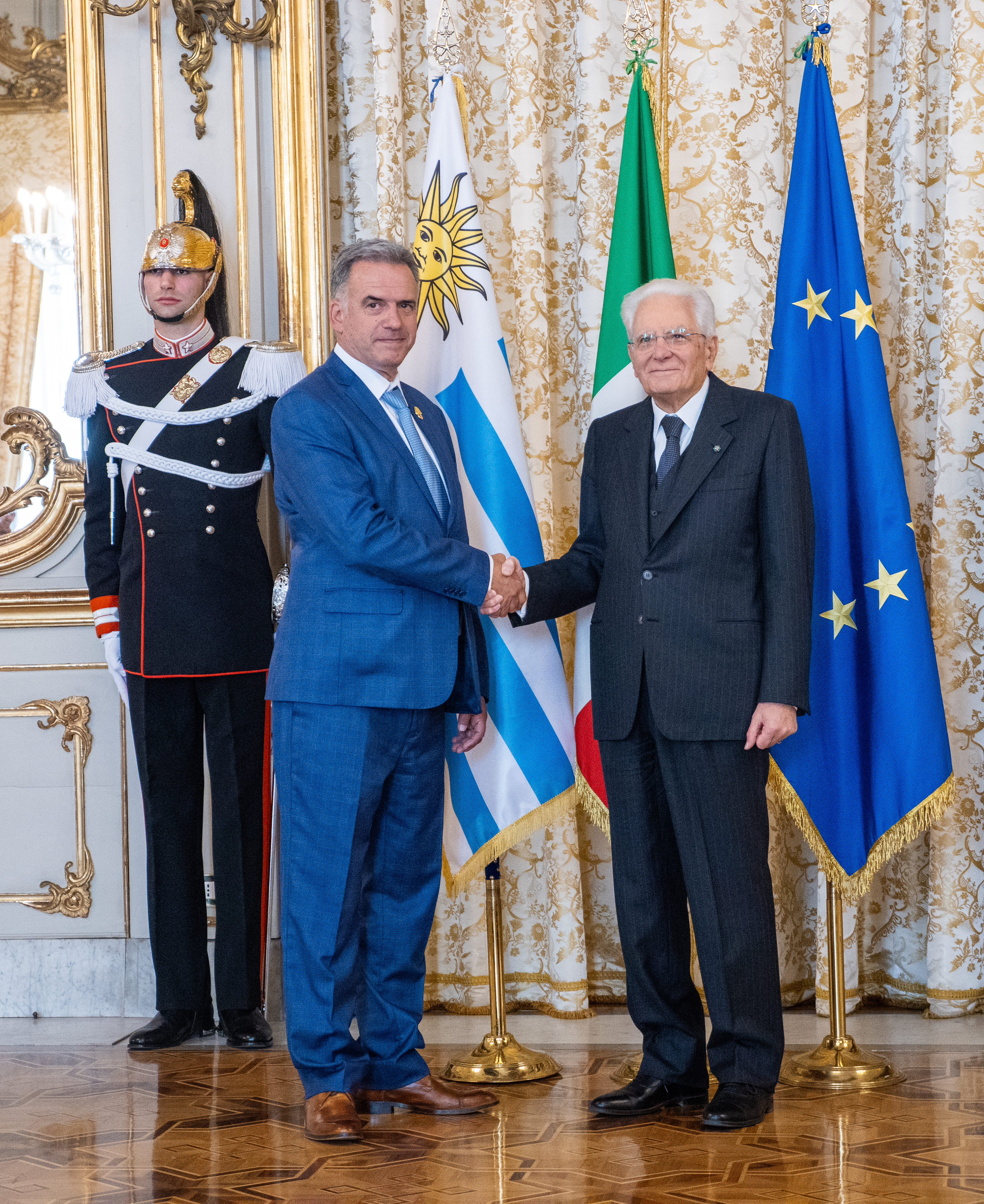 Plano general de los presidentes estrechándose la mano y posando sonrientes frente a cámara. 