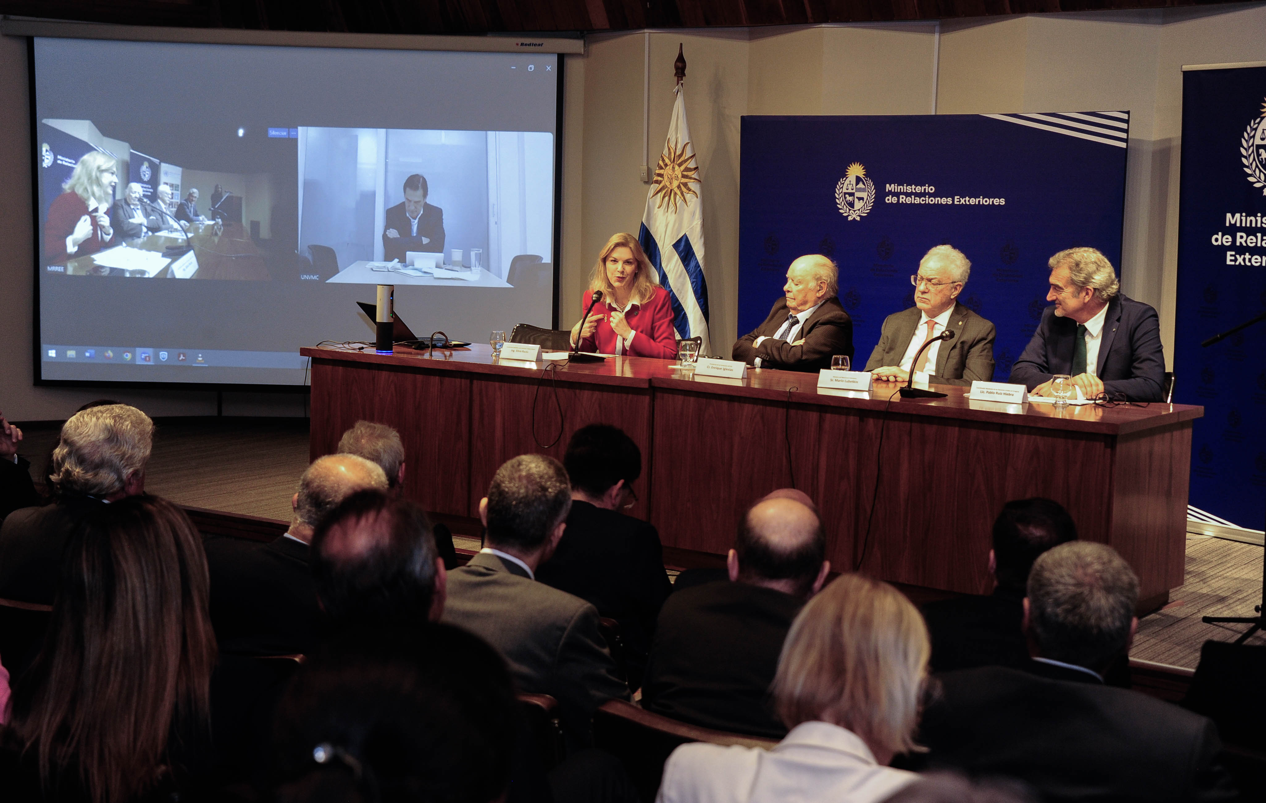 La coordinadora residente de ONU Brasil diserta sentada en mesa con micrófono mientras las demás autoridades la observan.