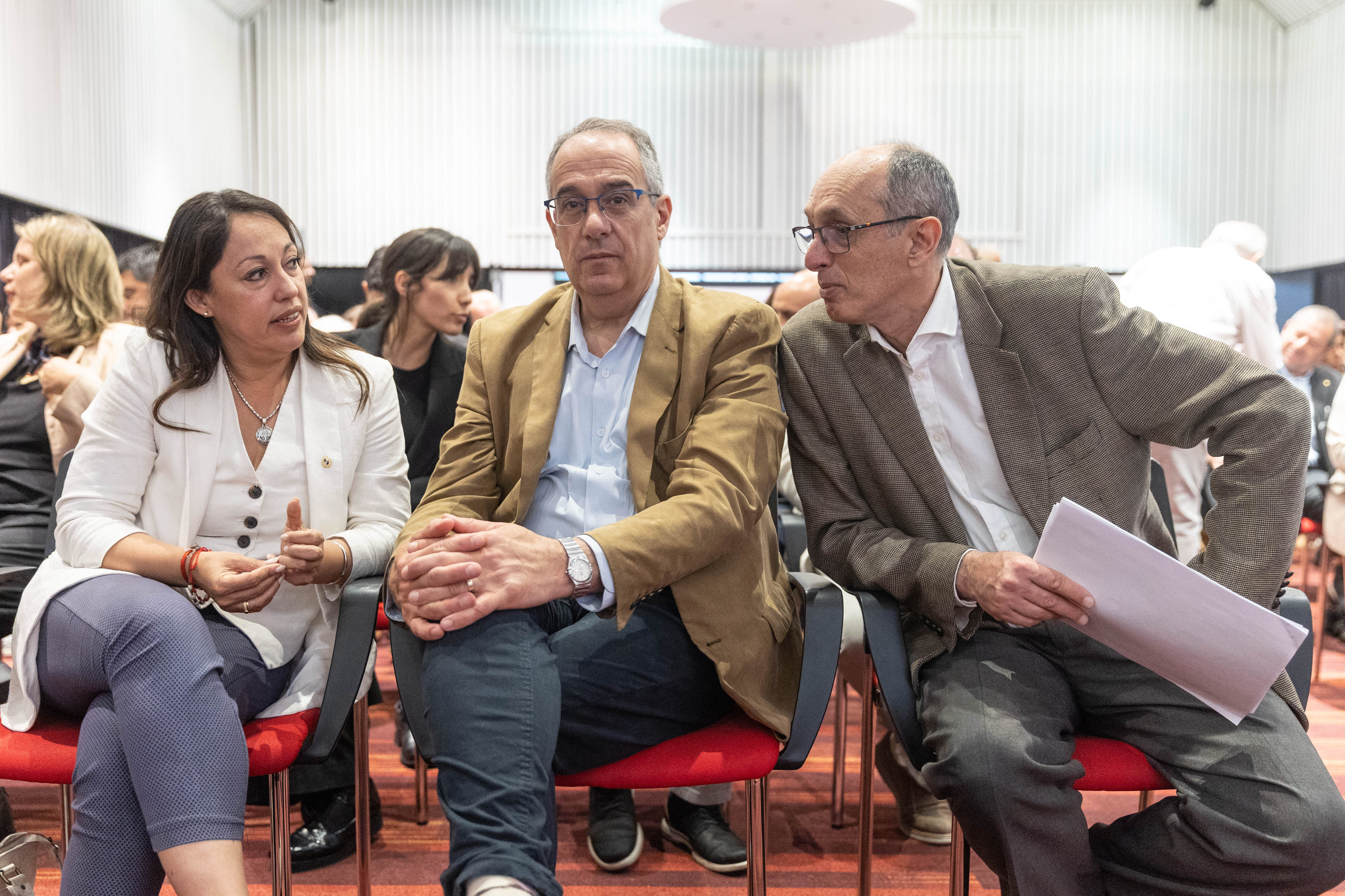 Ministros de Industria y Educación y Cultura conversan con el presidente de la CTM sentados en primera fila de la platea.