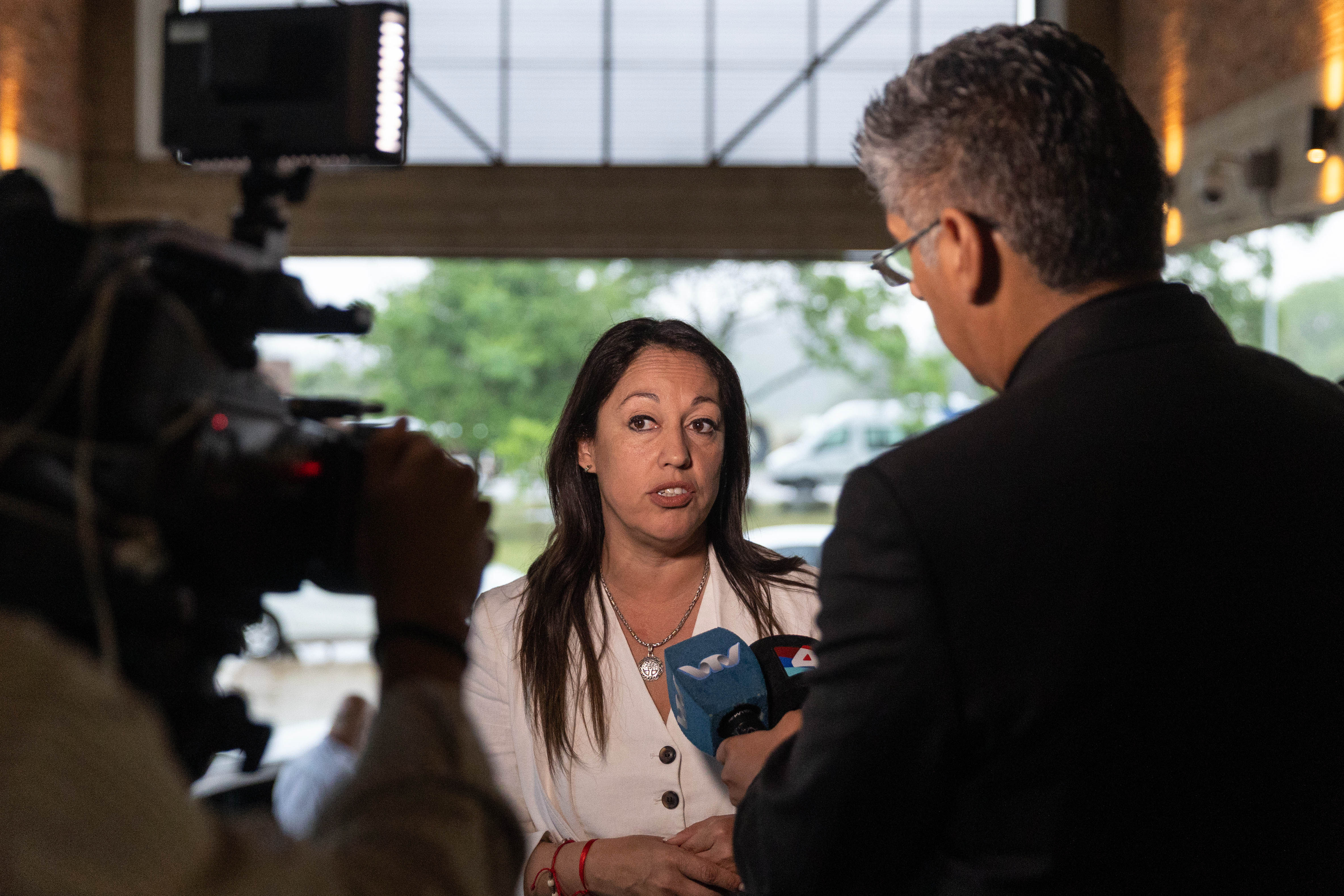 Ministra de Industria dialoga con periodistas frente a varios micrófonos de prensa.