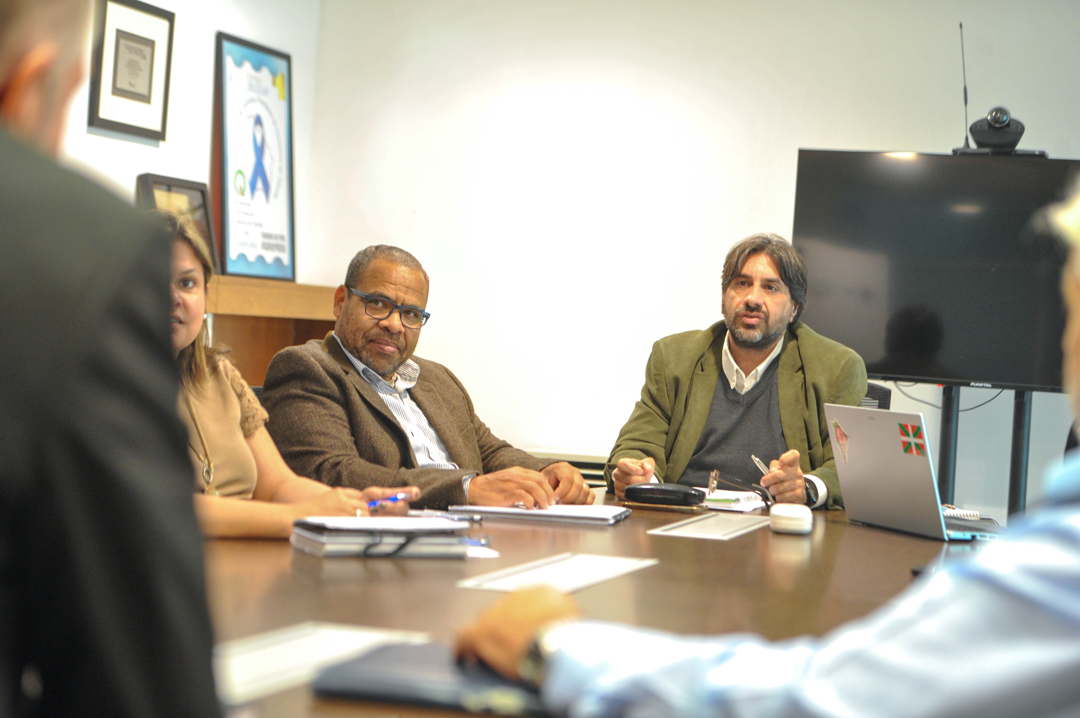 Presidente de Unasev y representantes de las intendencias sentados en mesa dialogan entre sí en una sala de reuniones.