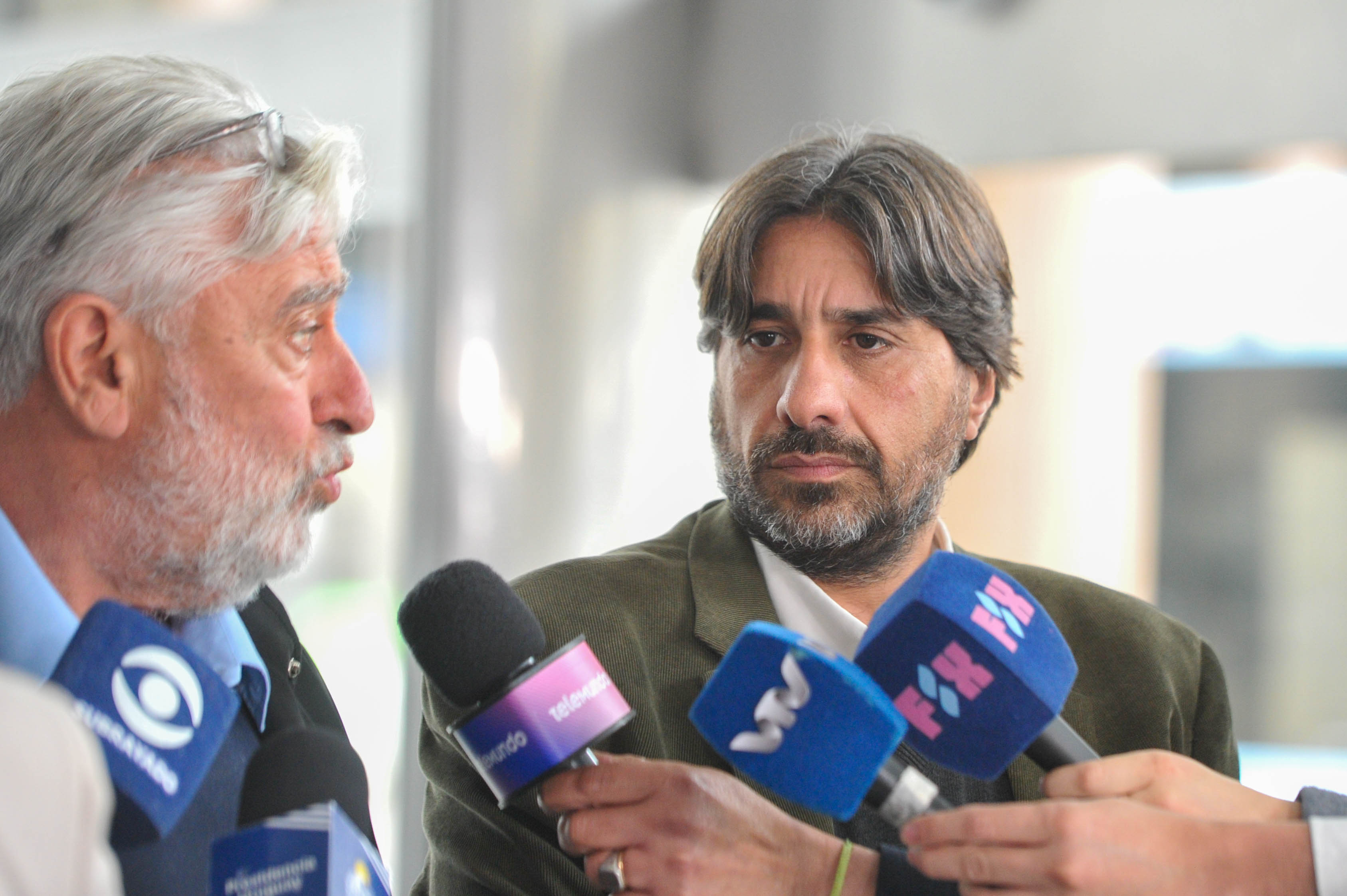 Representante municipal dialoga con periodistas frente a varios micrófonos de prensa. A su costado el presidente de Unasev lo observa.