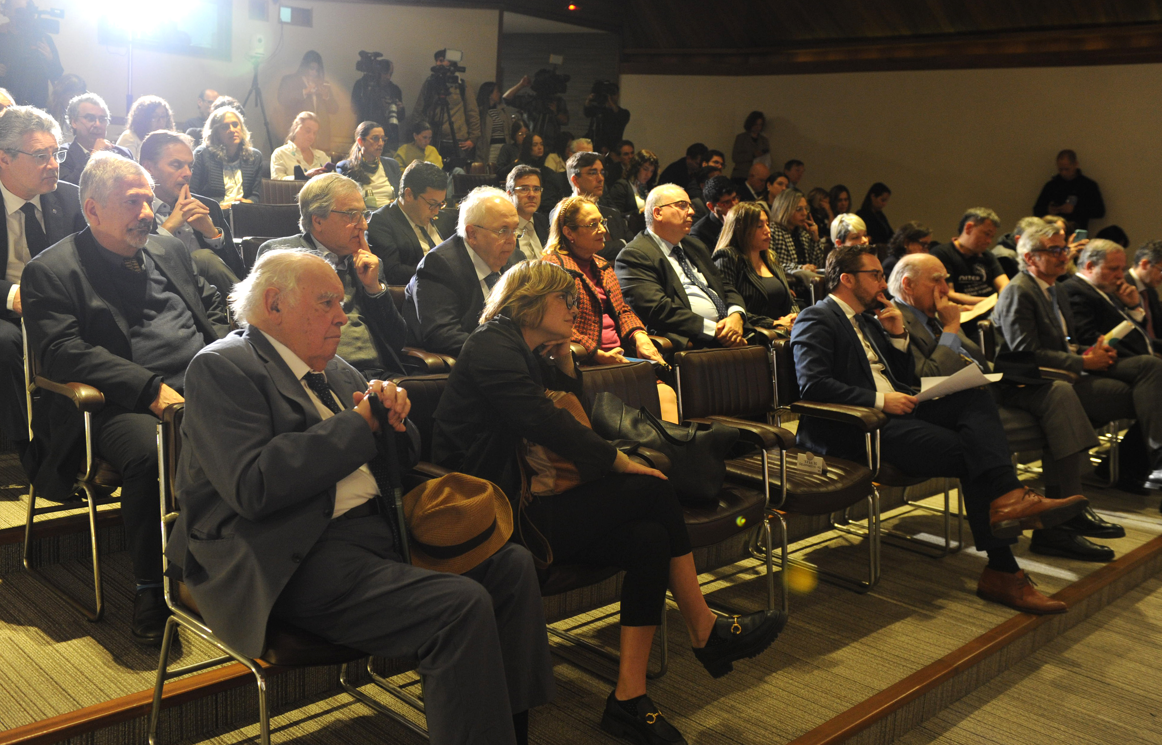 Público sentado en la platea mira hacia el escenario donde están disertando las autoridades.