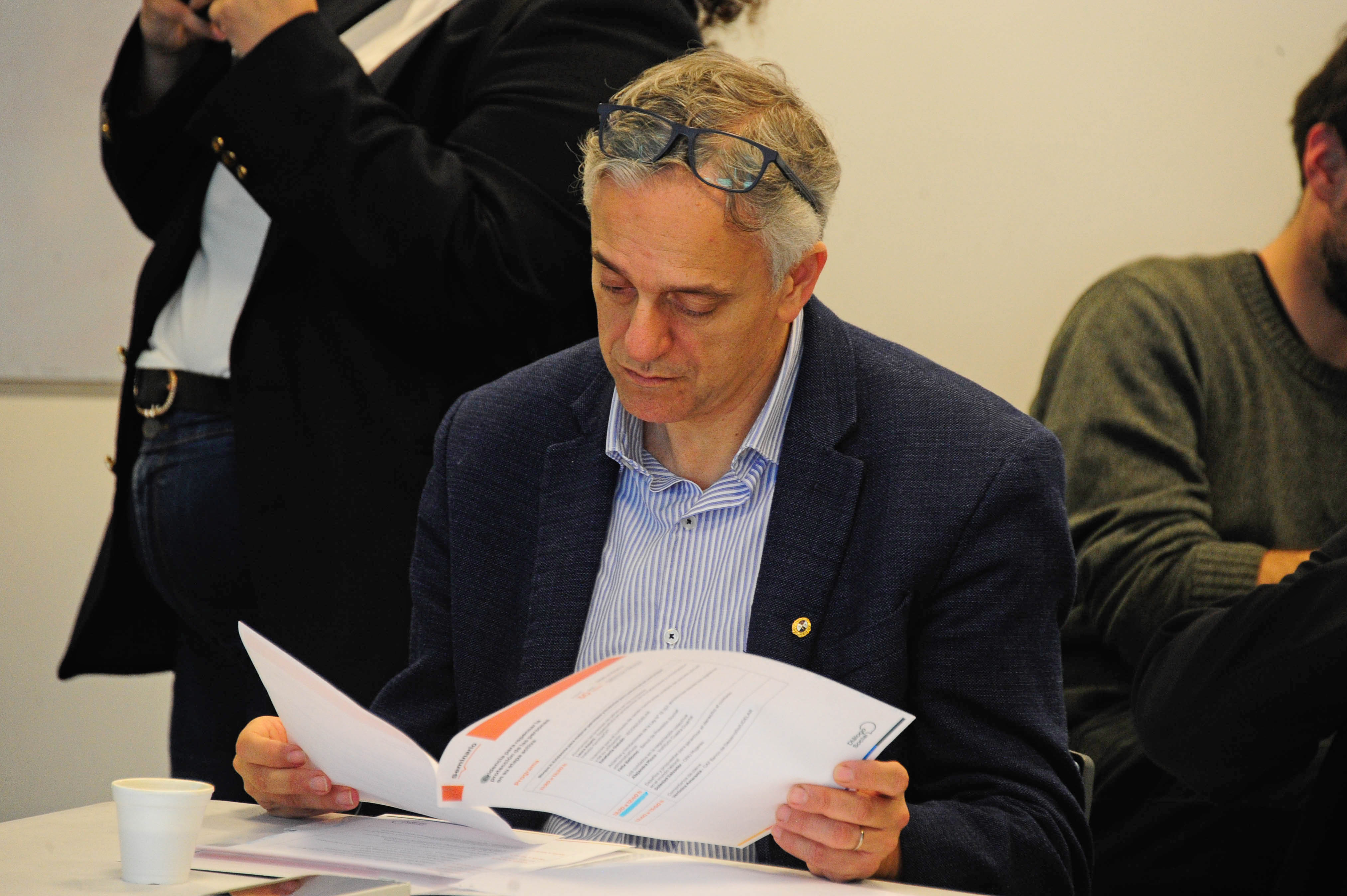 Director de Planeamiento y Presupuesto sentado mirando un documento en la sala de reuniones.