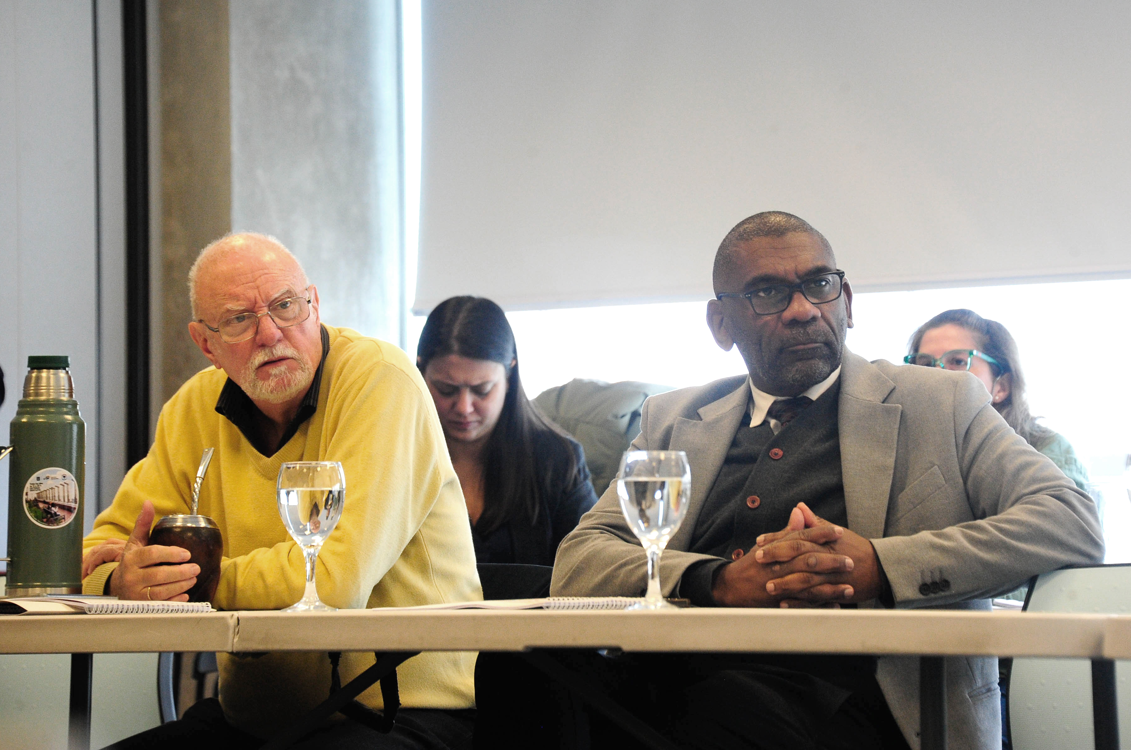 Ministro y subsecretario de Ambiente sentados escuchan atentos una disertación.