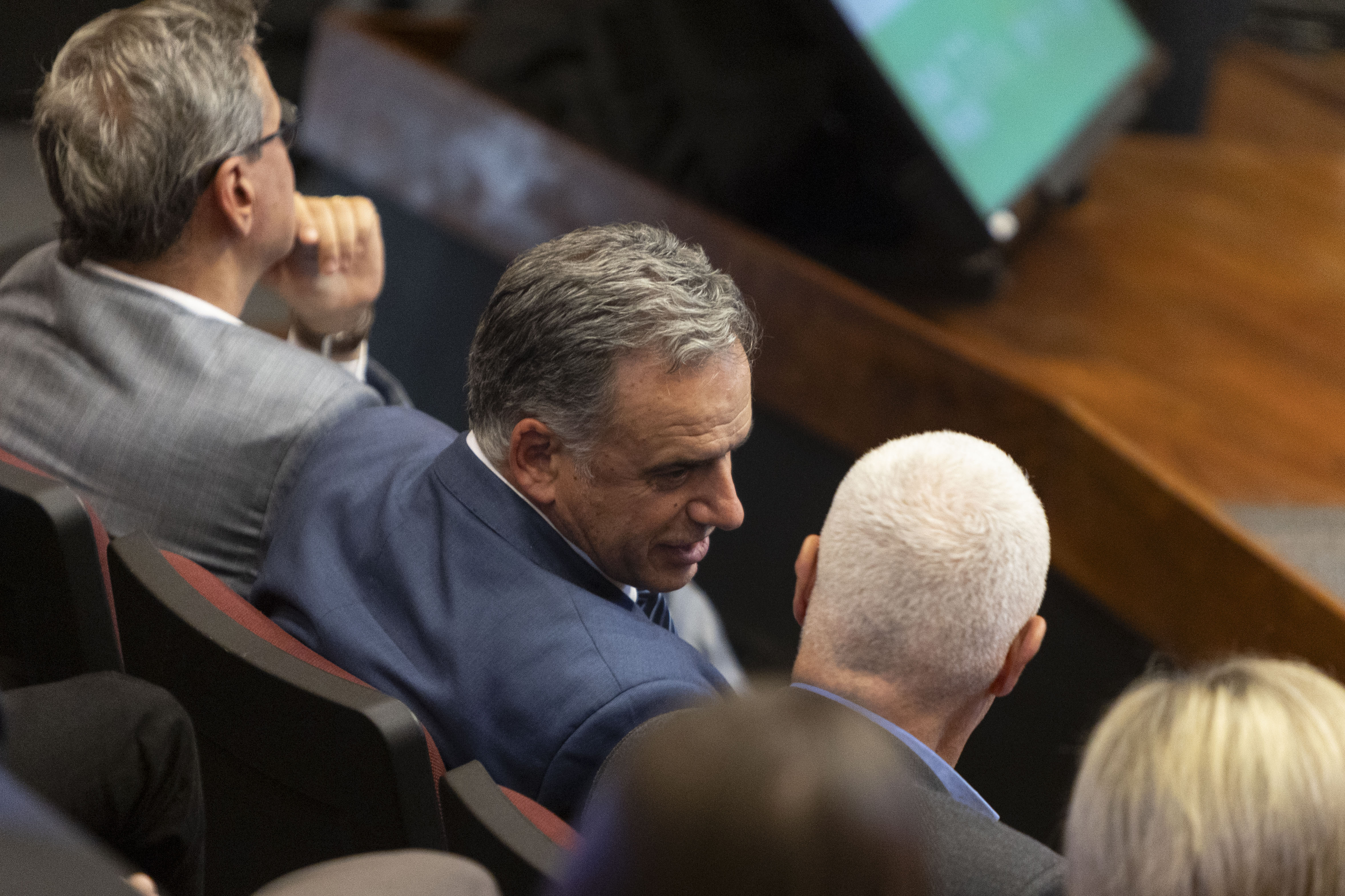 Orsi, de perfil, conversa con el ministro del Interior en la platea del auditorio.