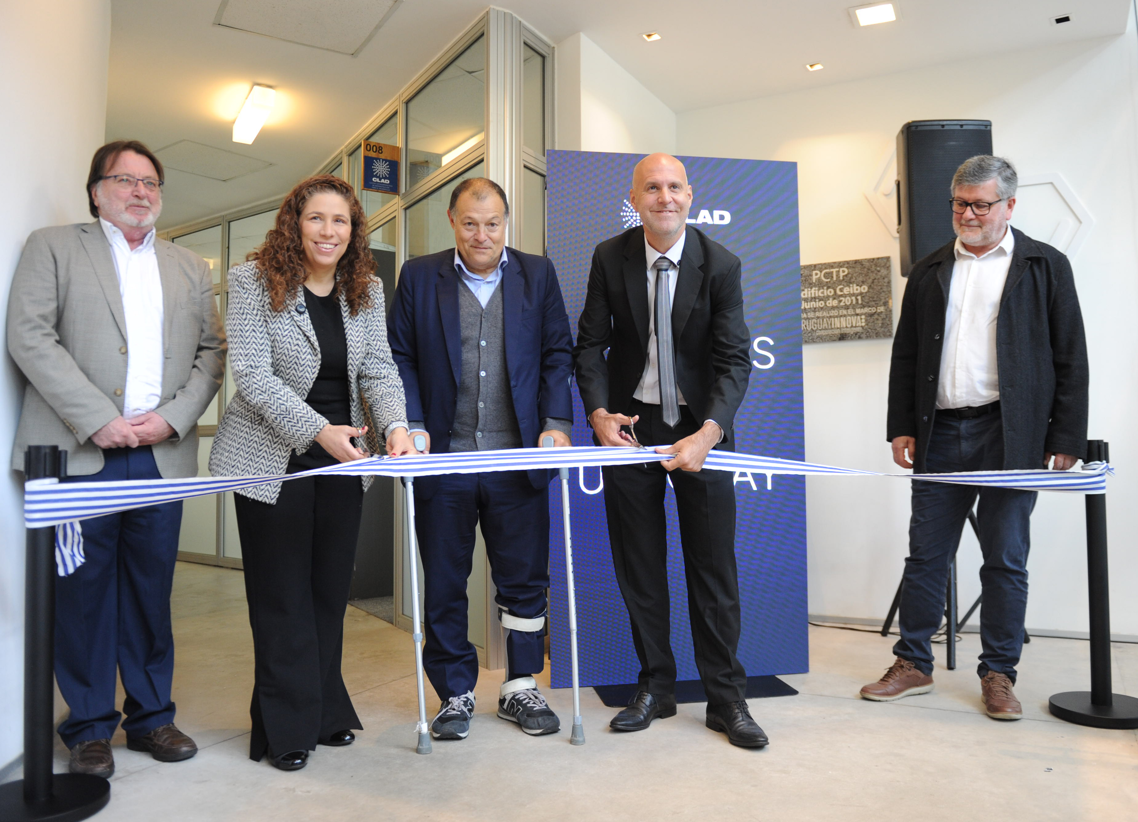 Autoridades de la oficina de Servicio Civil y del Centro Latinoamericano de Administración para el Desarrollo posan sonrientes cortando una cinta.