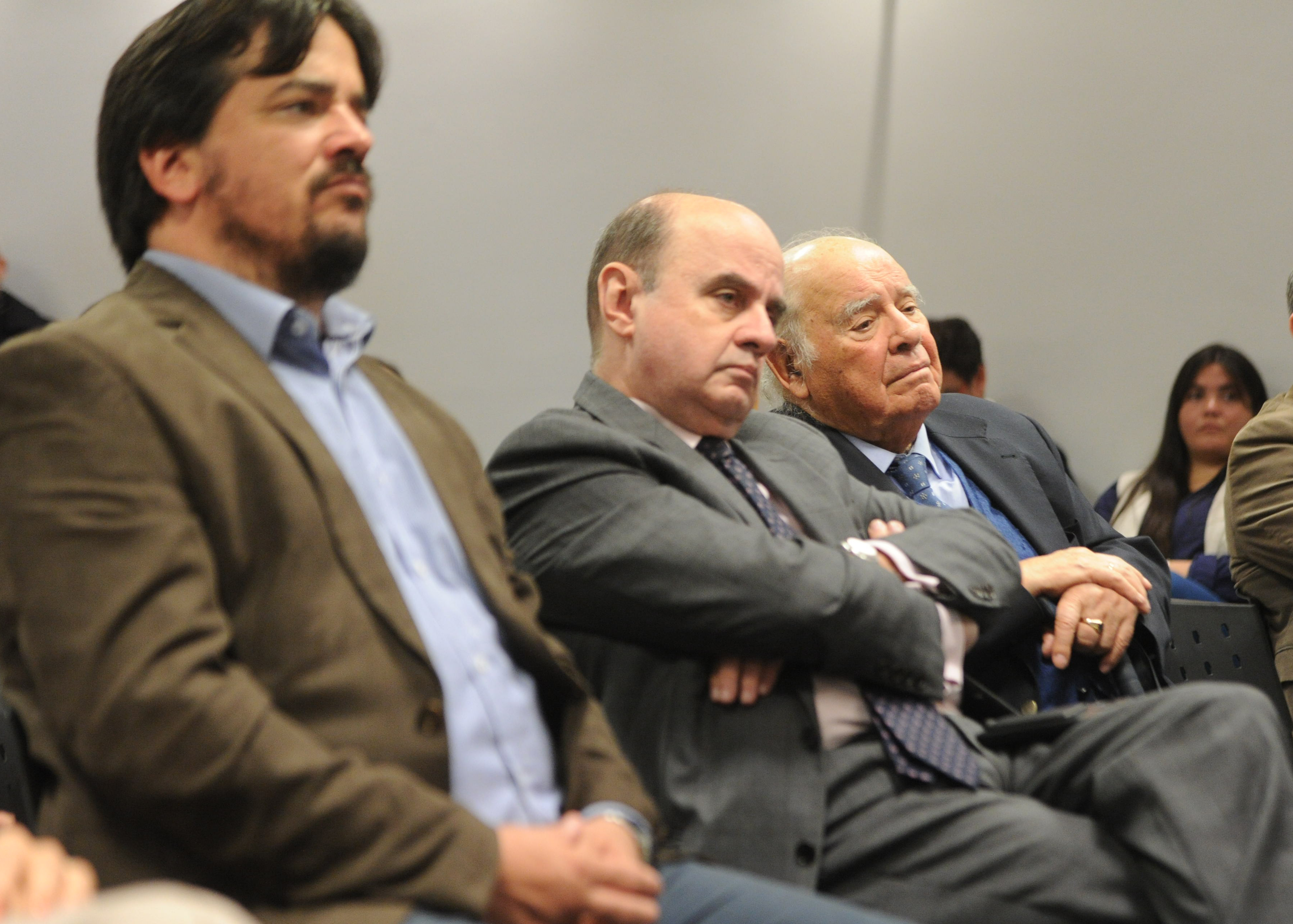 Presidente de la Fundación Astur junto a otros asistentes, sentados en la platea, escuchan con atención la conferencia.