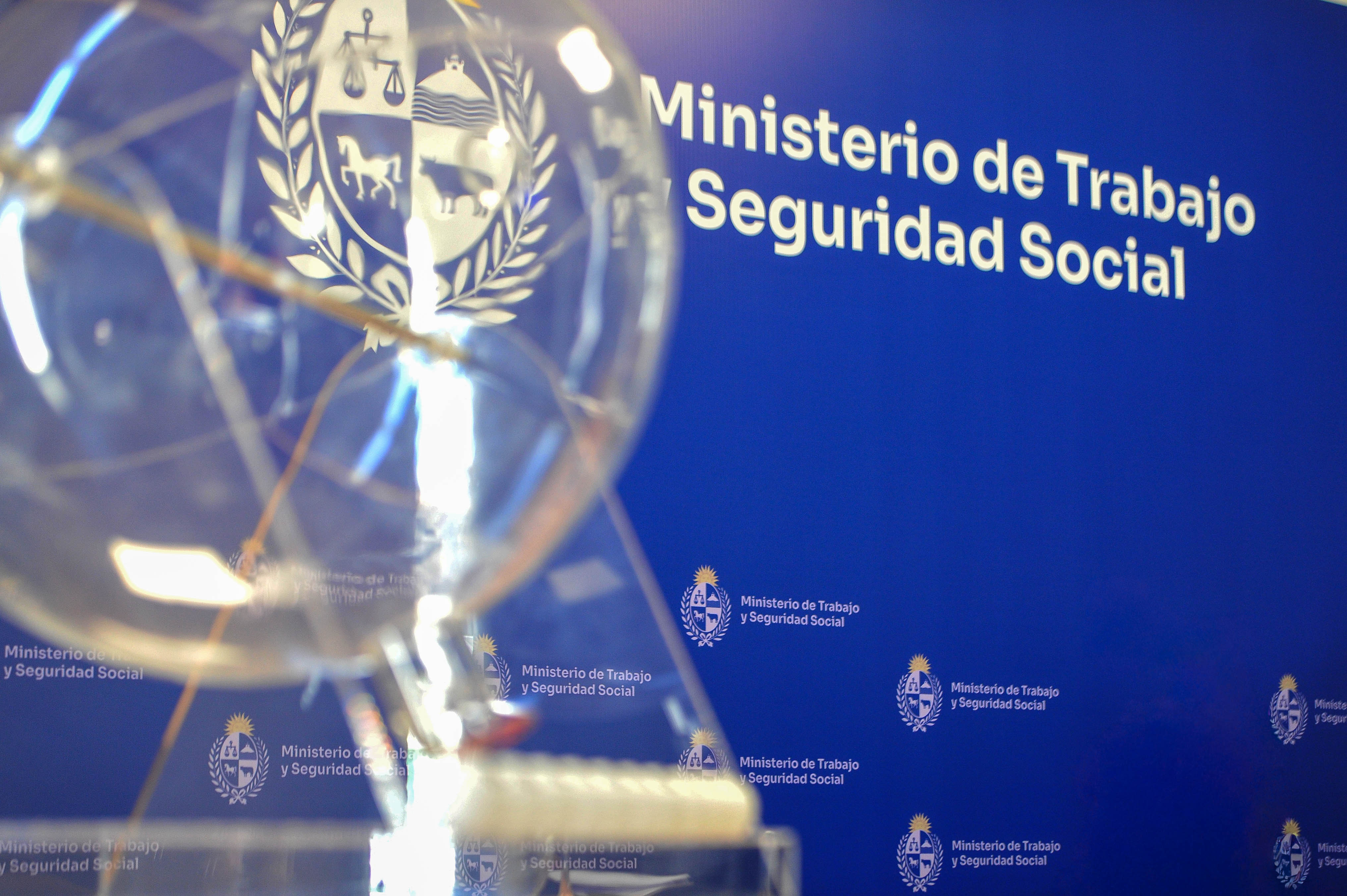 Pantalla en alto que muestra gráfico de barras "Número de puestos laborales por año" (2012-2025), en el salón de actos del MTSS.