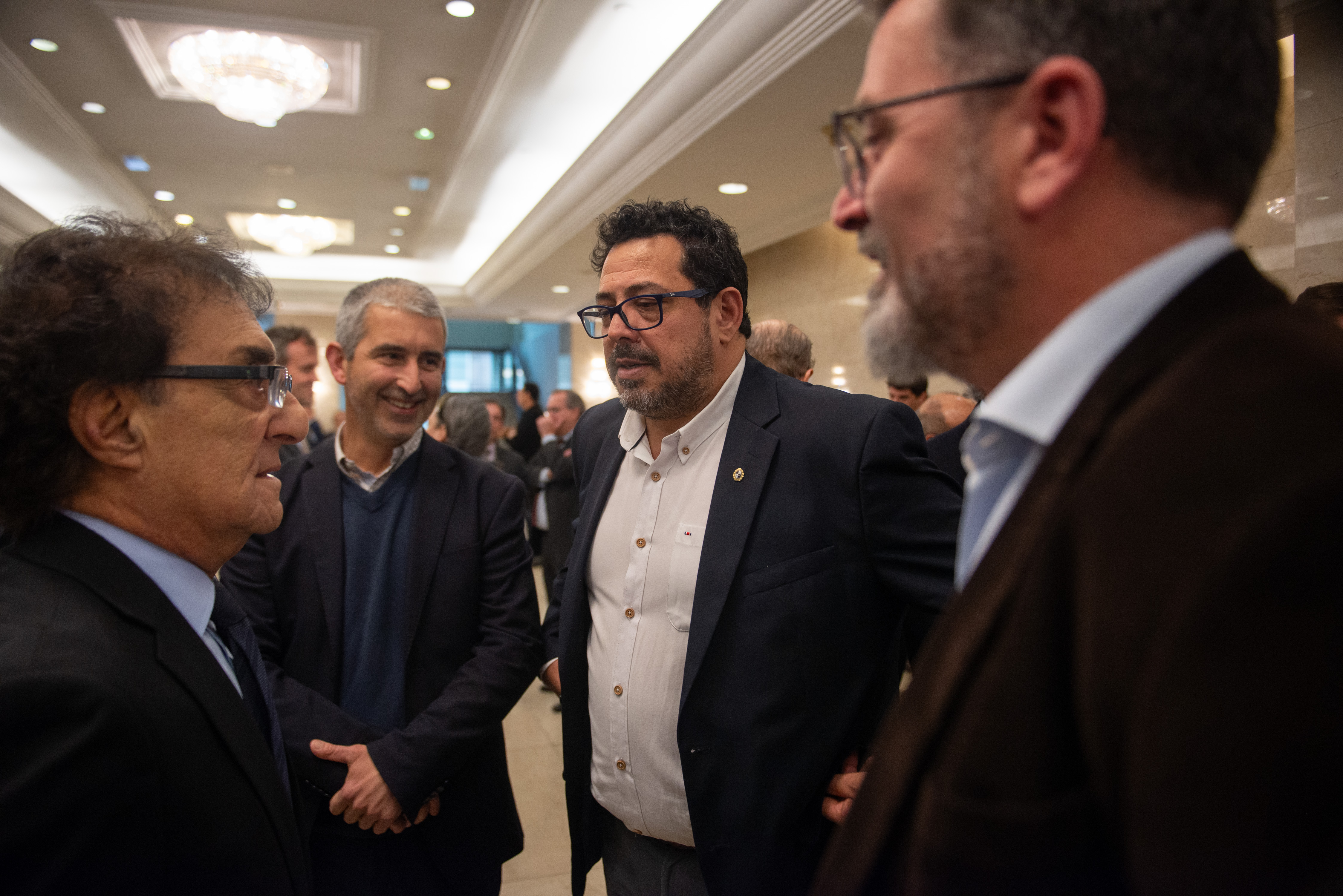 Secretario de Presidencia dialoga con el presidente de la ANEP y autoridades de ADM en la recepción de la sala de conferencias.