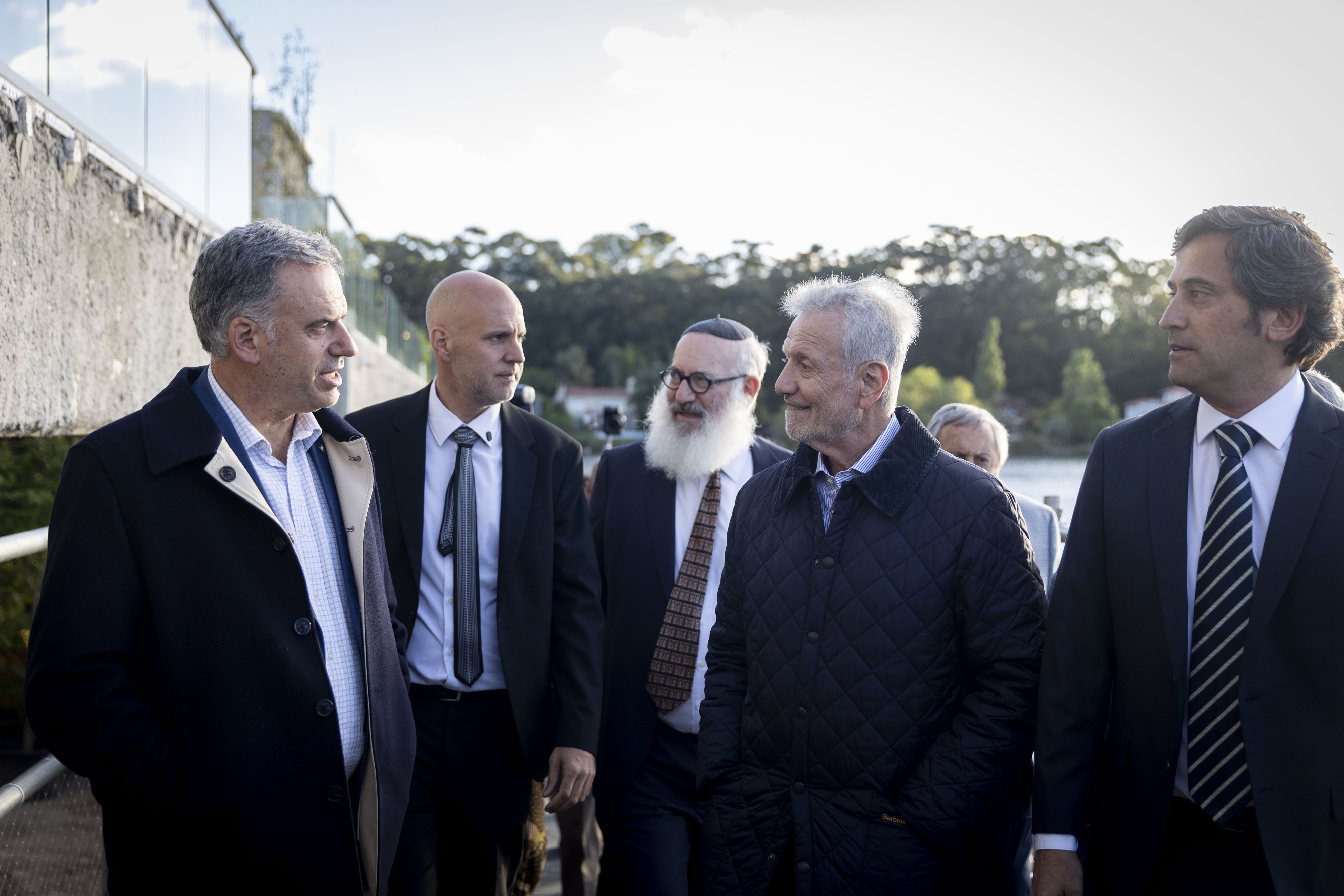 Orsi, el intendente de Canelones y autoridades de la Fundación Oftalmológica Argentina (FOA) dialogan de pie en el ingreso al nuevo centro.
