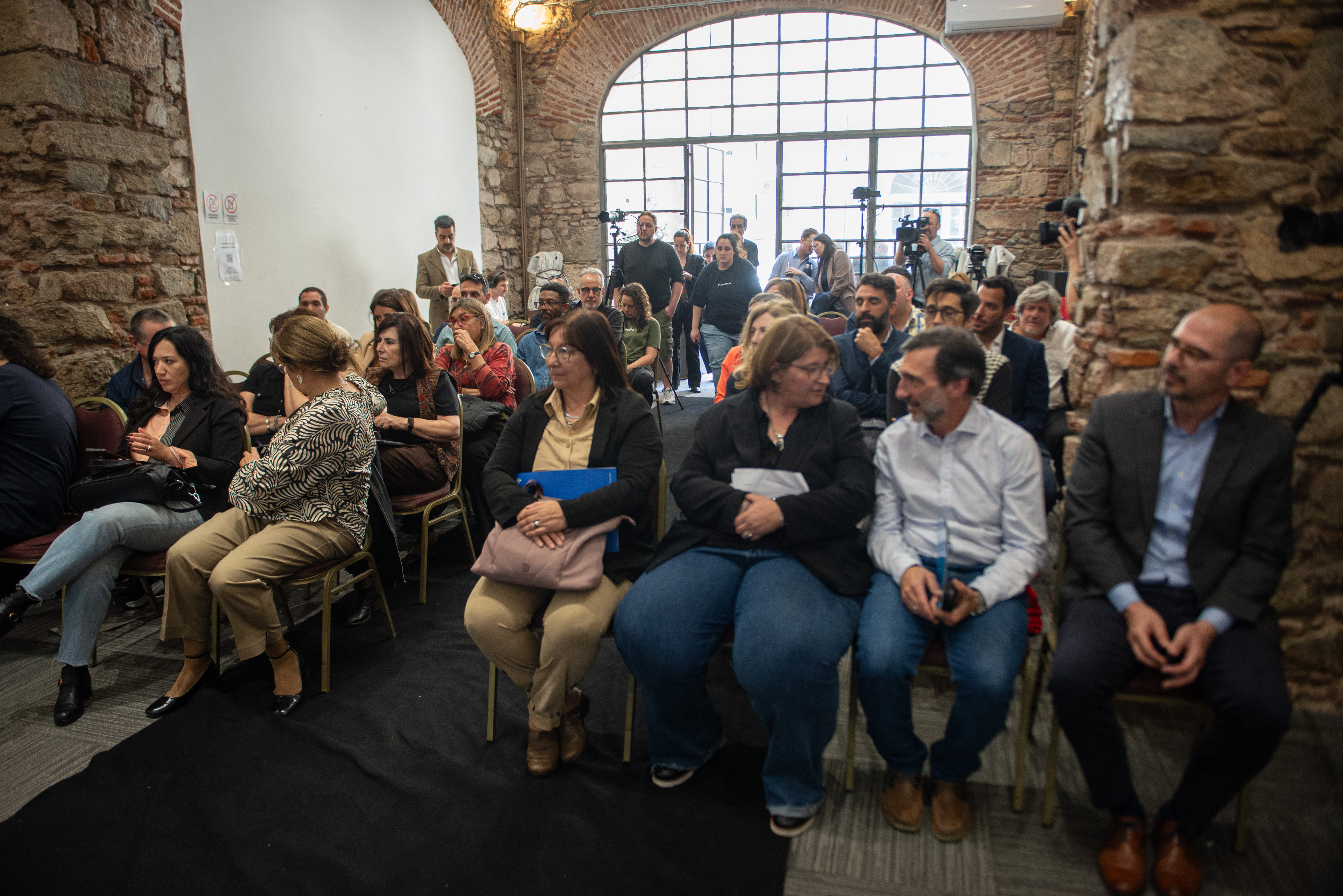 Público sentado en el salón de actos de la UTU mira hacia el escenario, escuchando atentamente una disertación.
