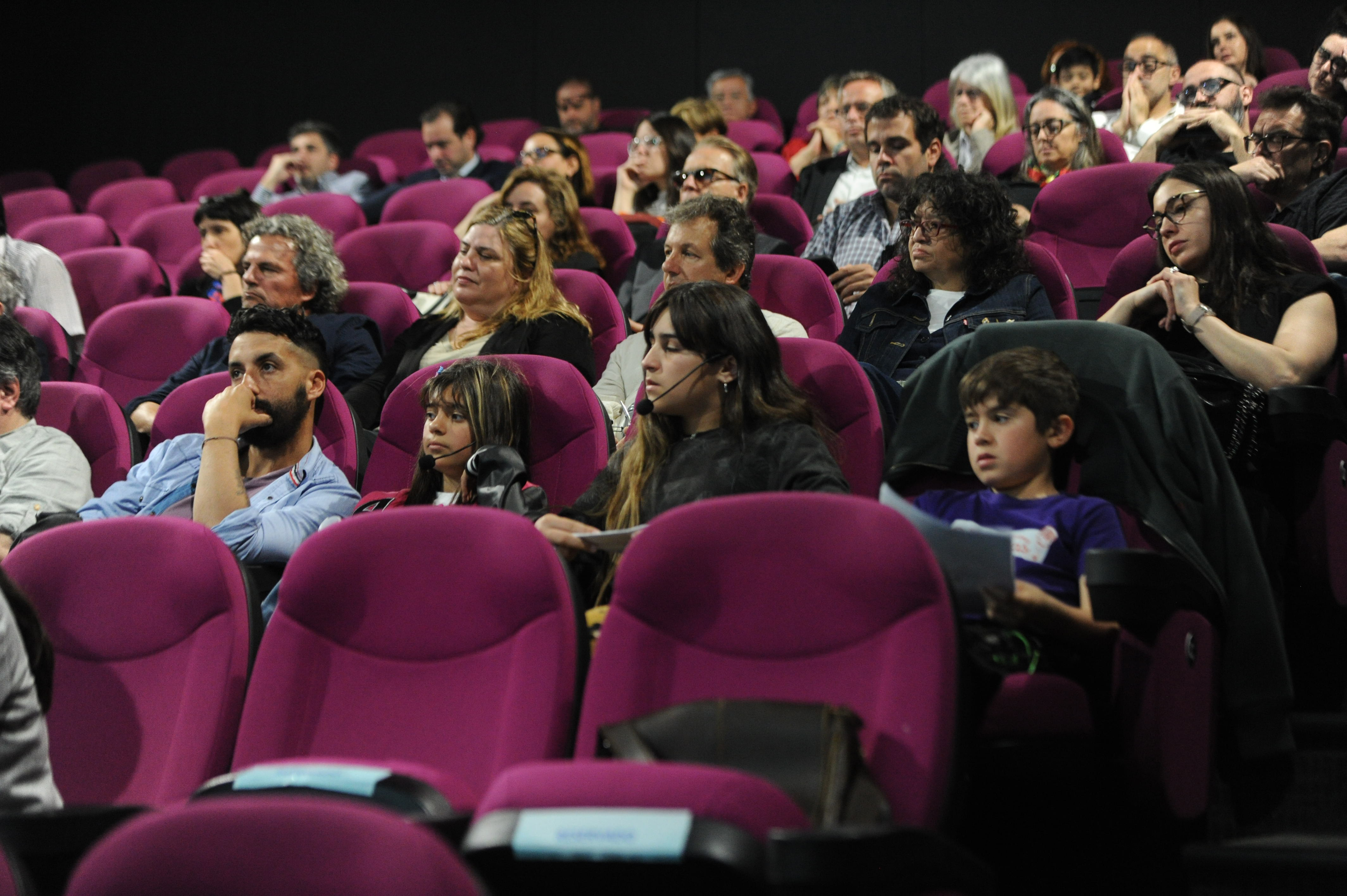 Público sentado en la platea mira hacia el escenario donde las autoridades disertan.