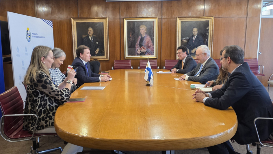 El canciller, el ministro de Comercio Exterior de Finlandia y delegaciones de ambos países dialogan en una sala de reuniones.