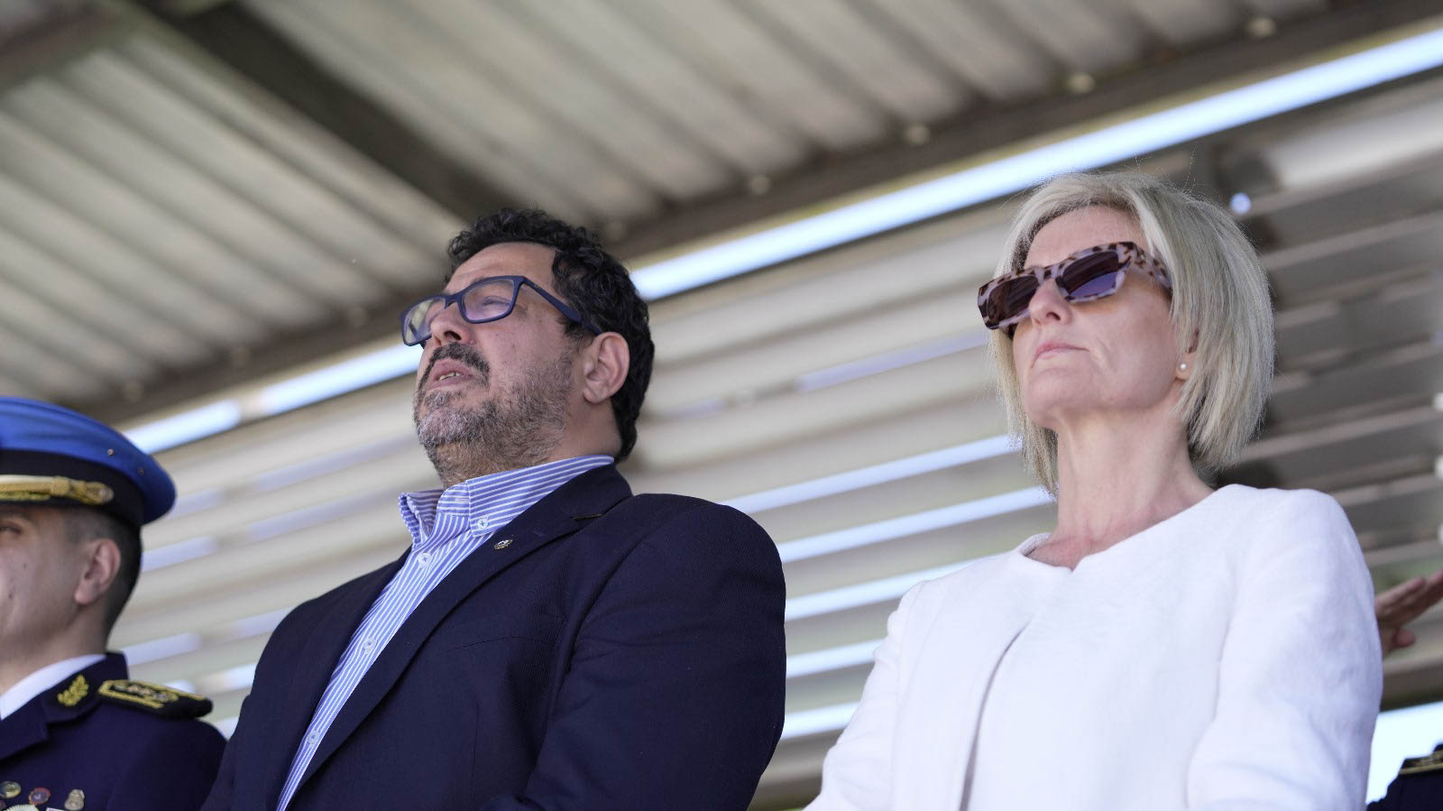 Secretario de Presidencia y subsecretaria del Interior, de pie, en el palco oficial instalado en Plaza de Armas de Dirección Nacional de la Educación.