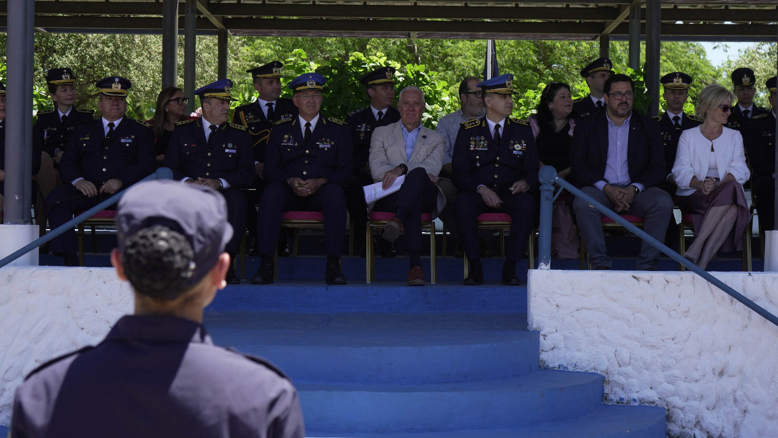 Secretario de Presidencia, ministro y subsecretaria del Interior y autoridades policiales sentadas en el palco oficial mirando la ceremonia.