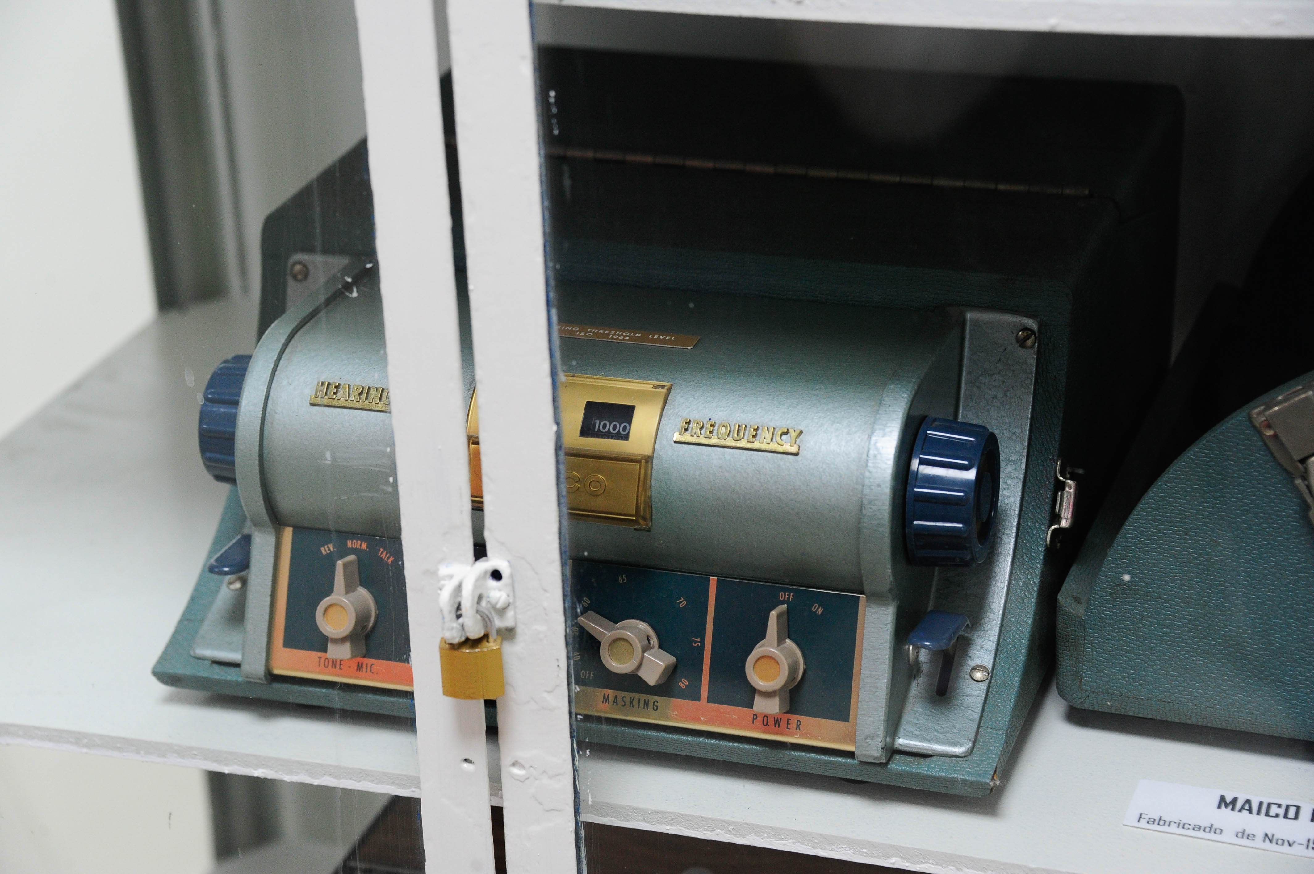 Primer plano de una vitrina que contiene un audiómetro antiguo.