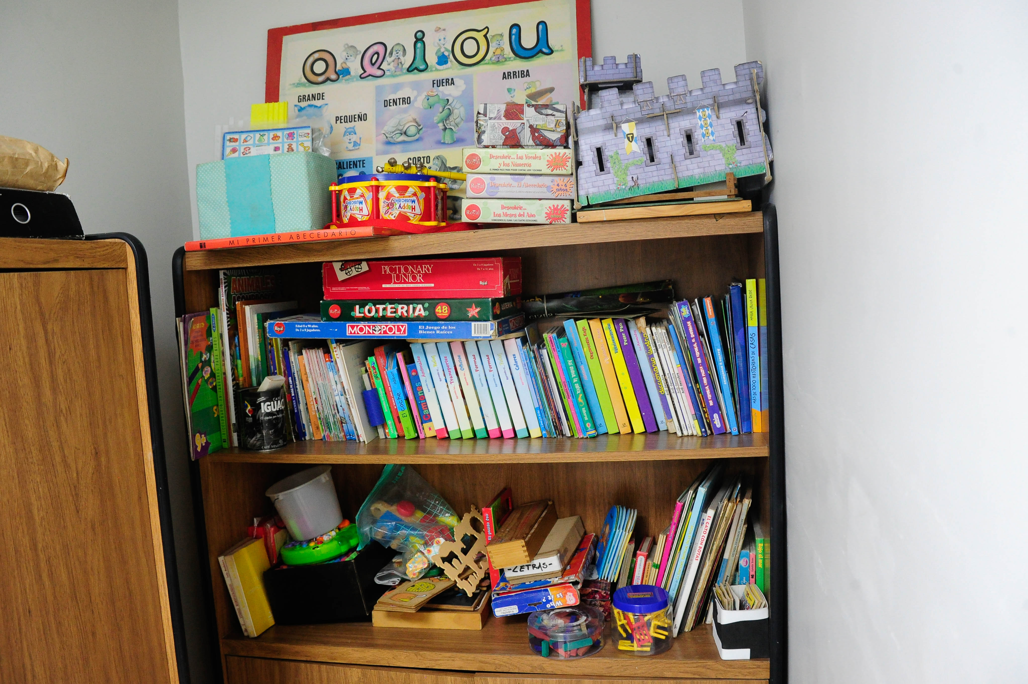 Plano general de un mueble con útiles escolares, libros y juegos para niños.