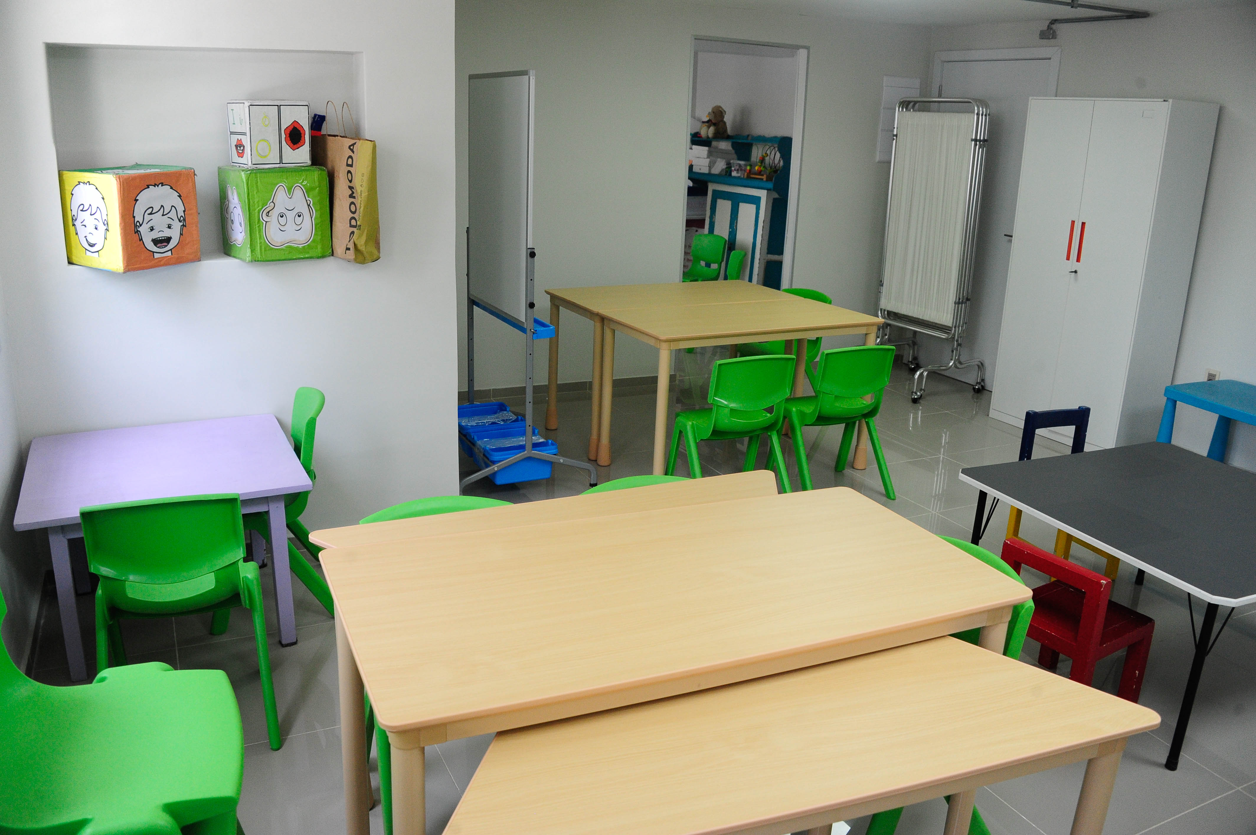 Otro plano de la sala de estar con sillas y mesas pequeñas.