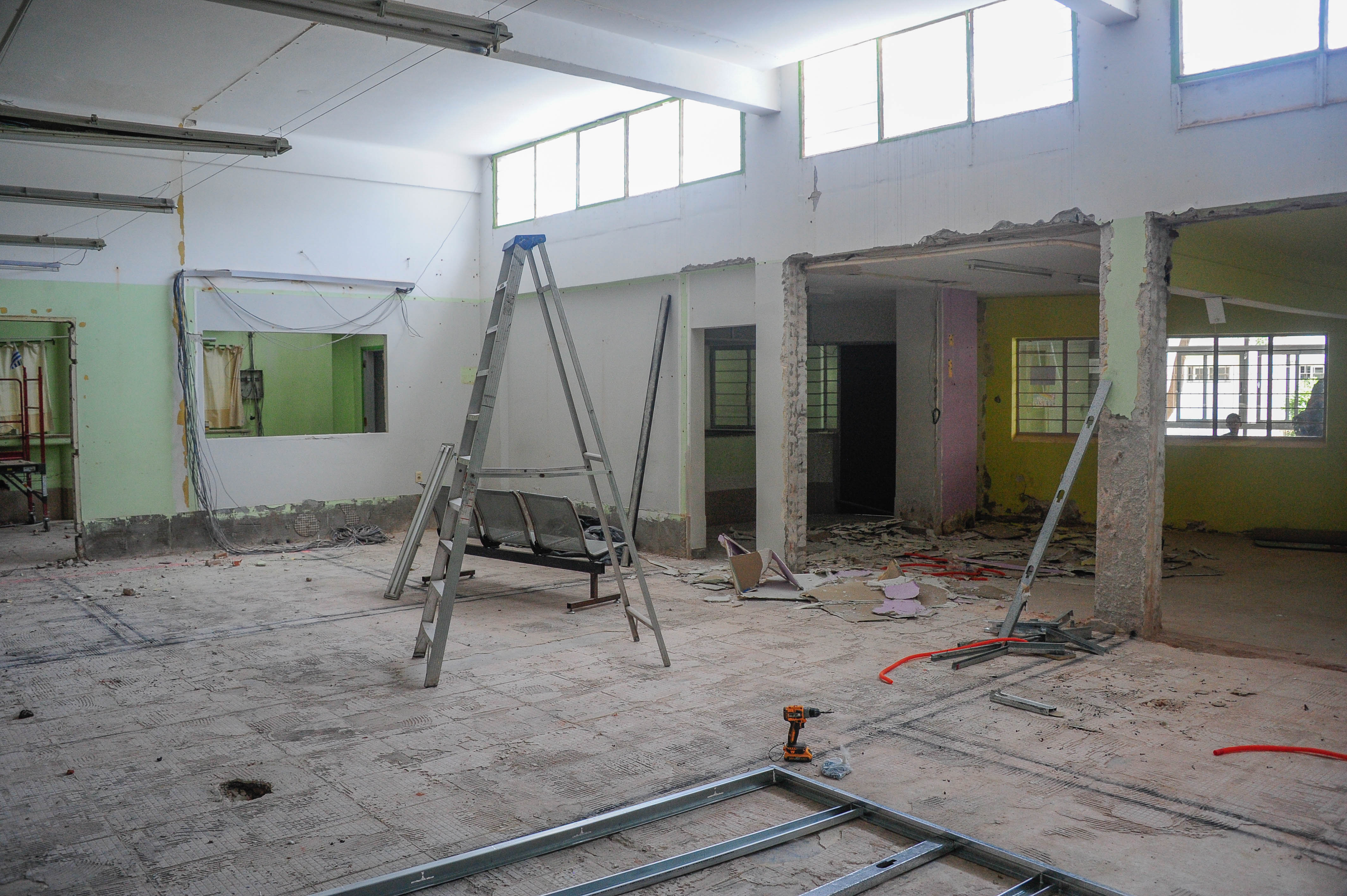 Otro plano de la sala donde se están haciendo reformas. Hay una escalera en el medio y un taladro.
