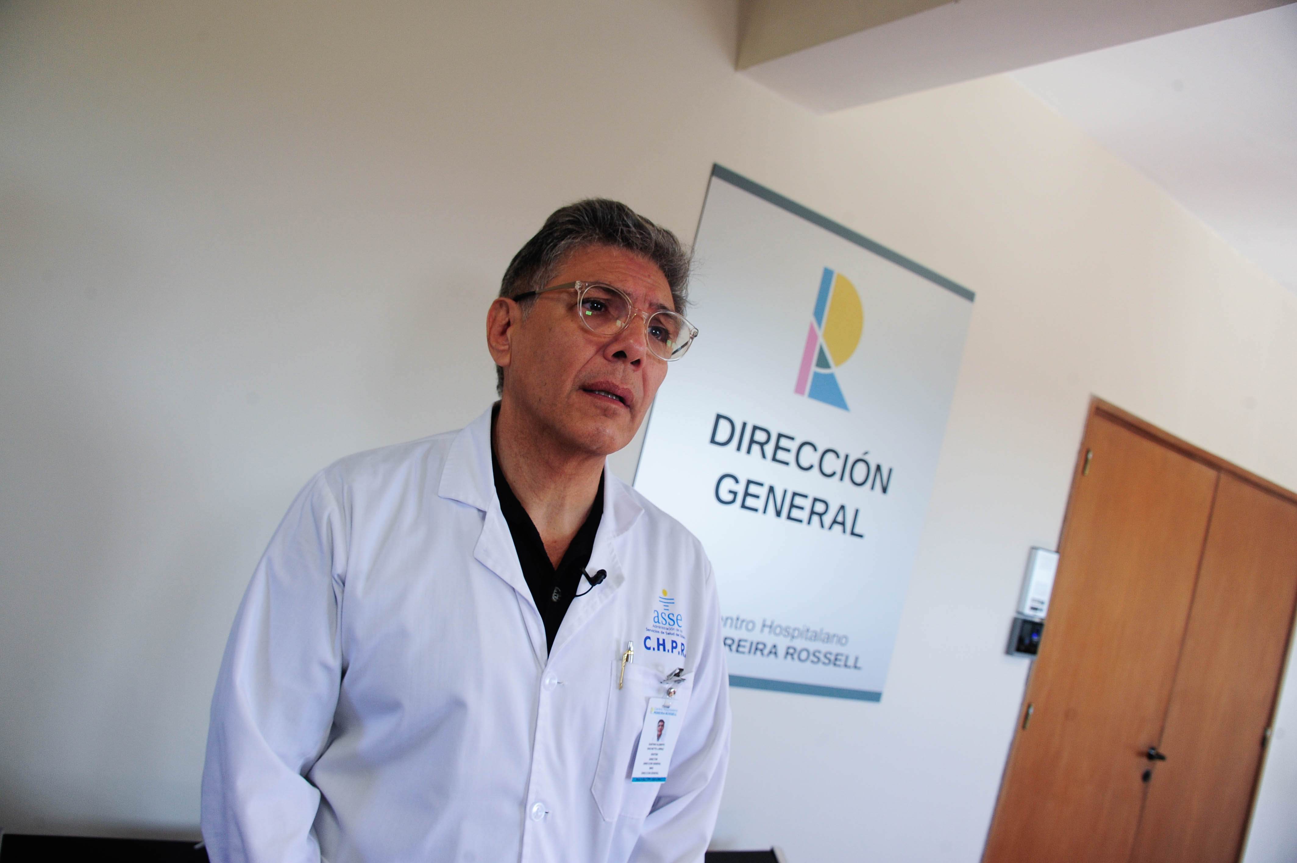 Director general del Centro Hospitalario Pereira Rossell de pie en un consultorio mira hacia adelante.