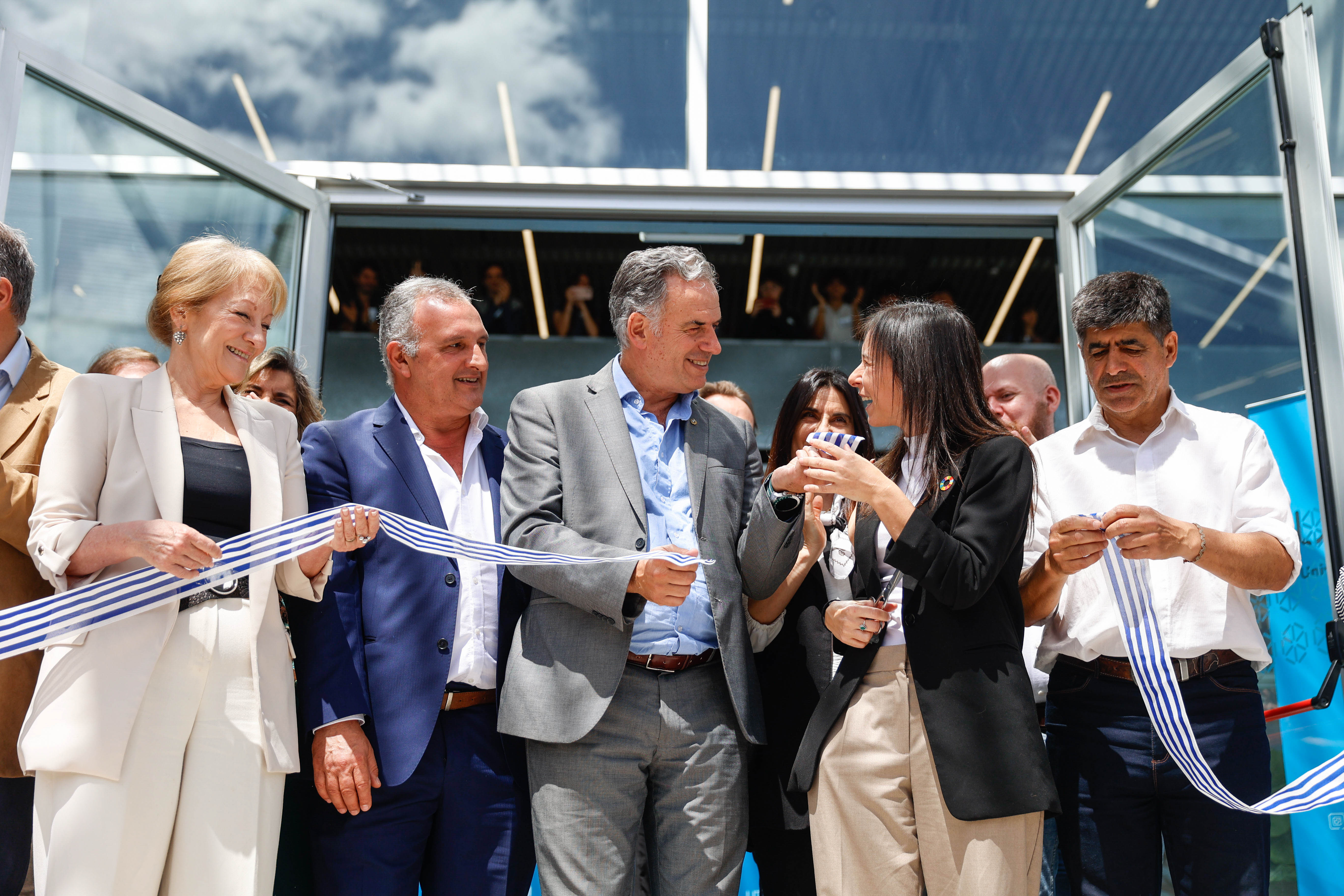 Orsi junto a la vicepresidenta de la República, la rectora de UTEC, el intendente de Lavalleja y otros asistentes corta la cinta de inauguración.
