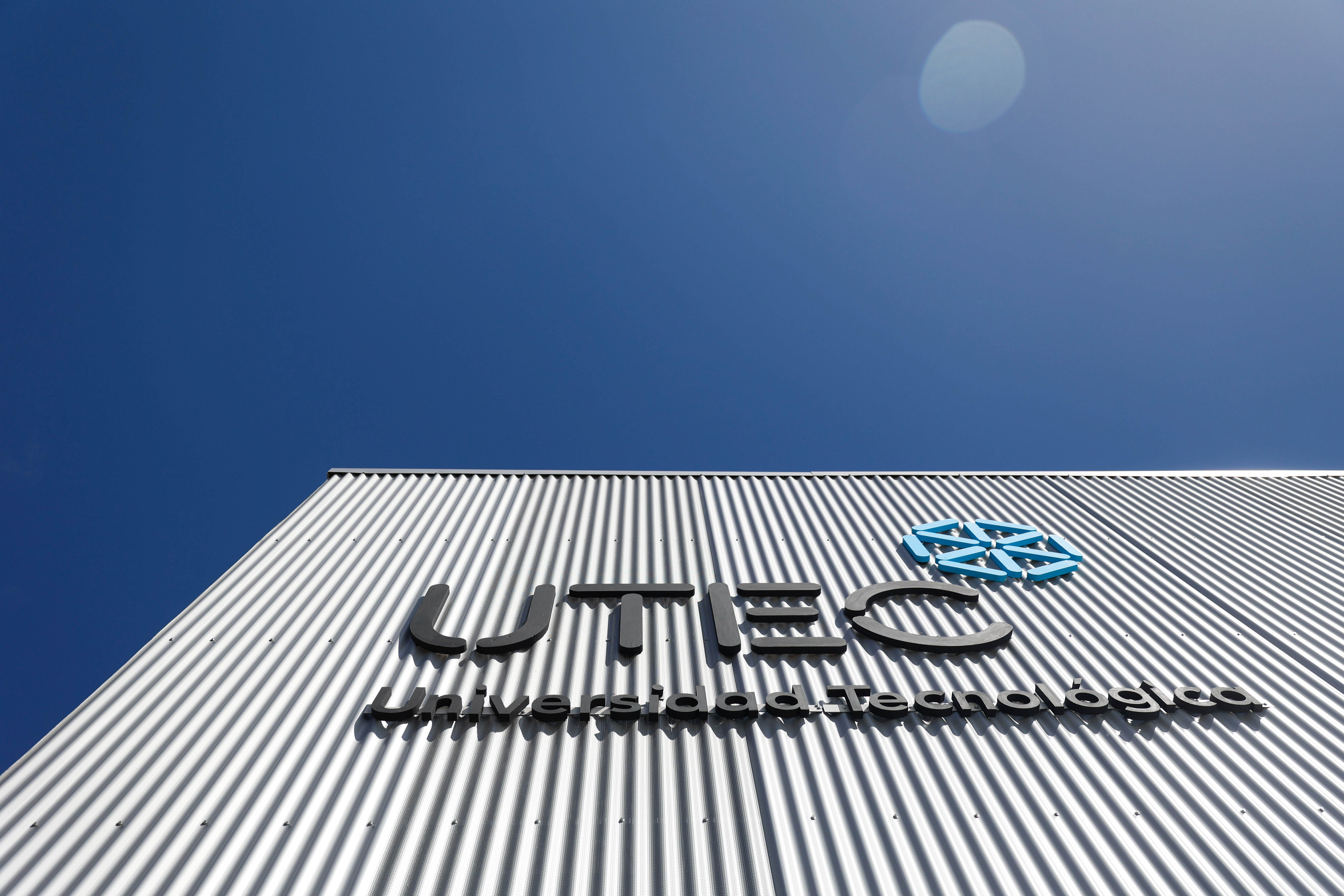 Plano contrapicado del cartel de UTEC (Universidad Tecnológica) en la fachada metálica del Instituto Tecnológico Regional de Lavalleja.