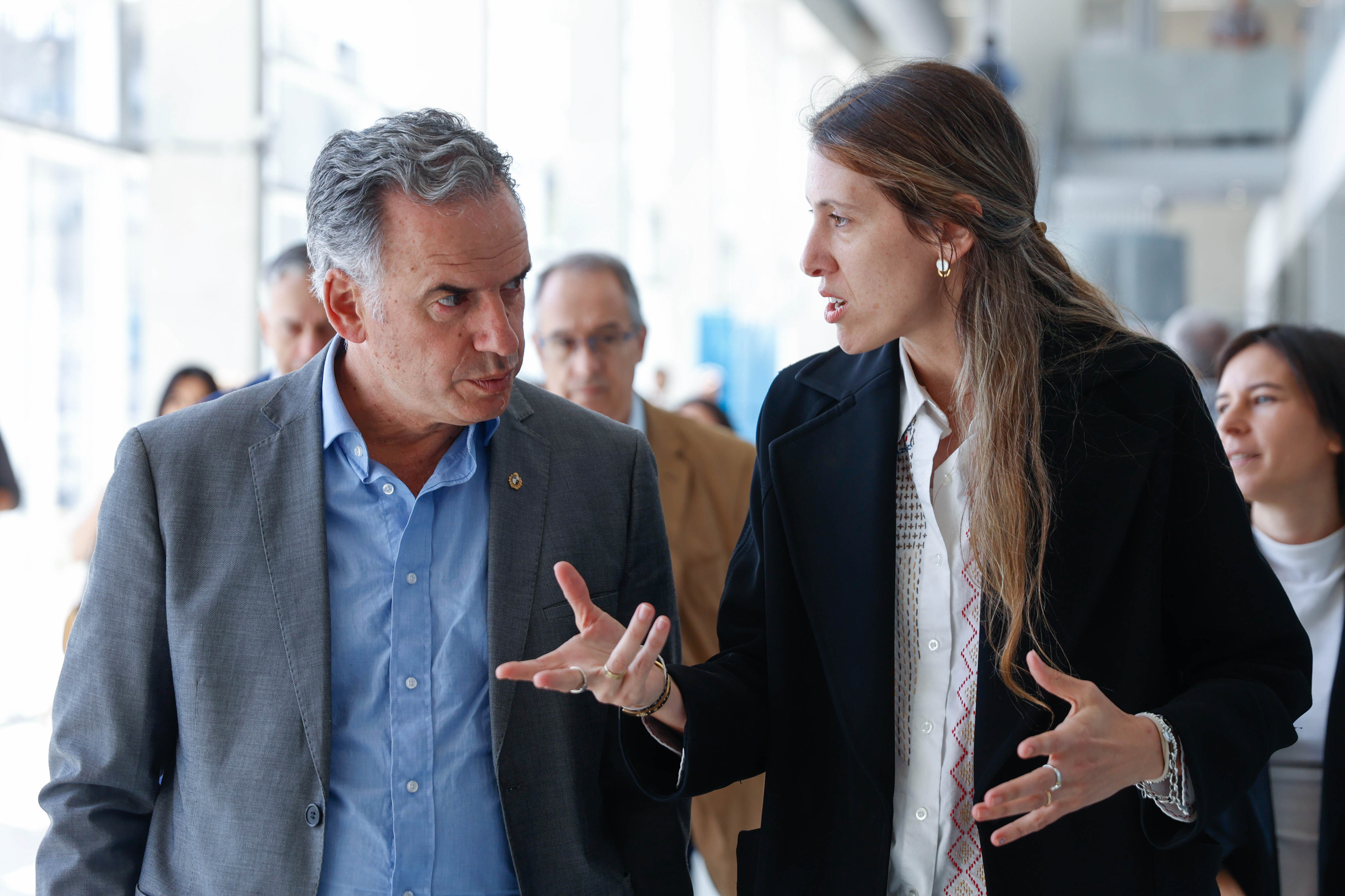 Orsi dialoga con una representante de UTEC mientras recorren las instalaciones del nuevo edificio. Atrás hay más autoridades.